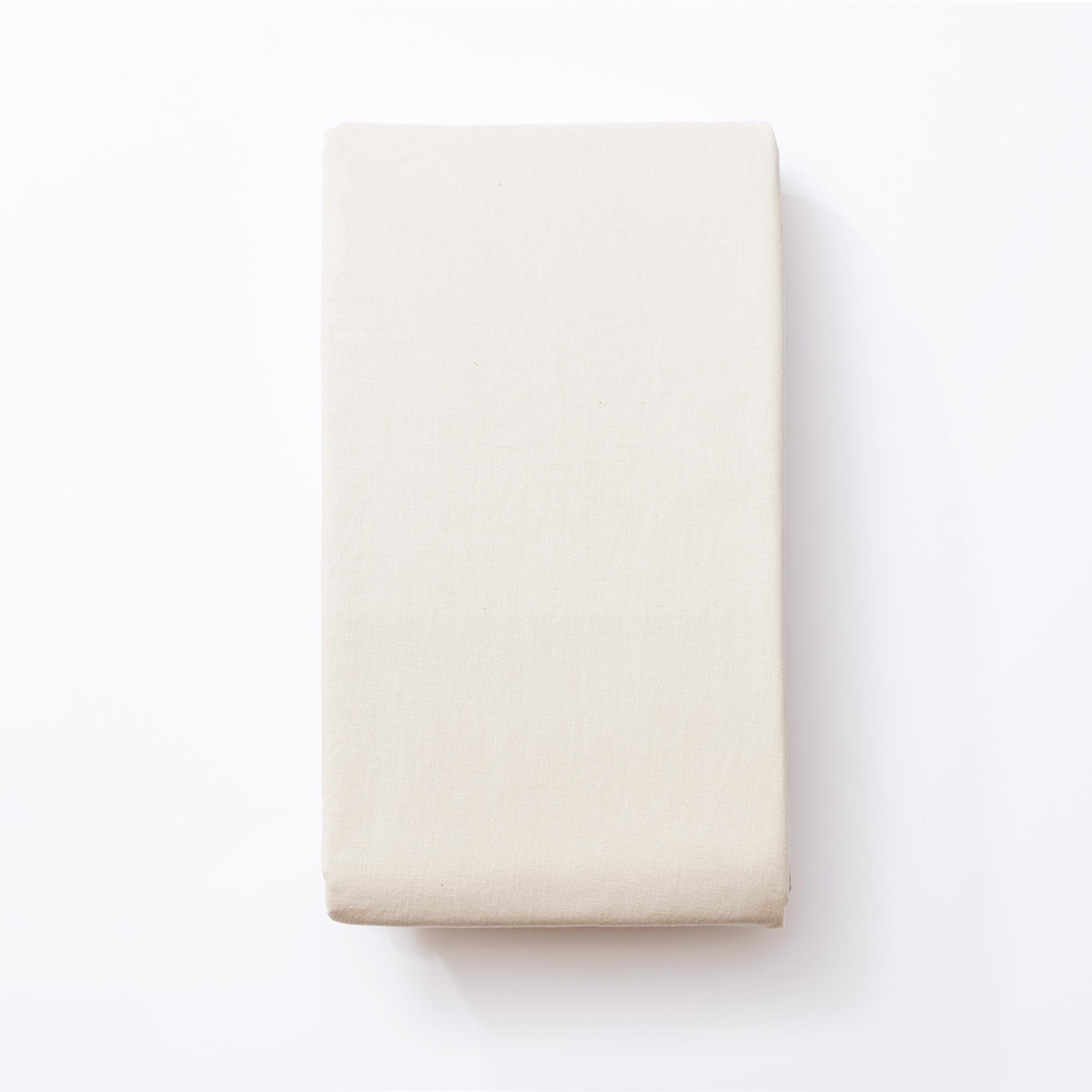 Una sábana beige clara doblada sobre fondo blanco.