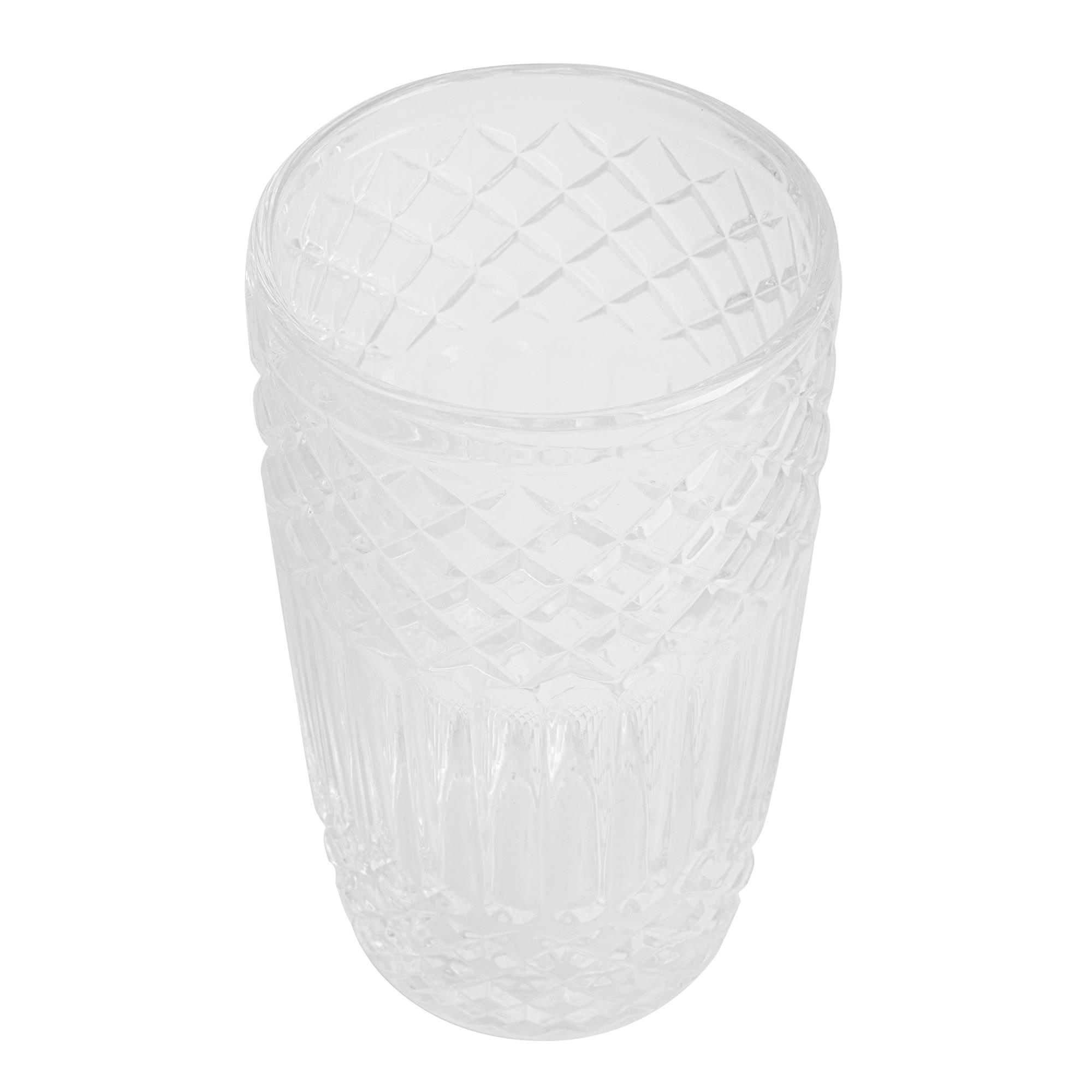 Un vaso de vidrio transparente y vacío con patrón de diamantes y estrías verticales.