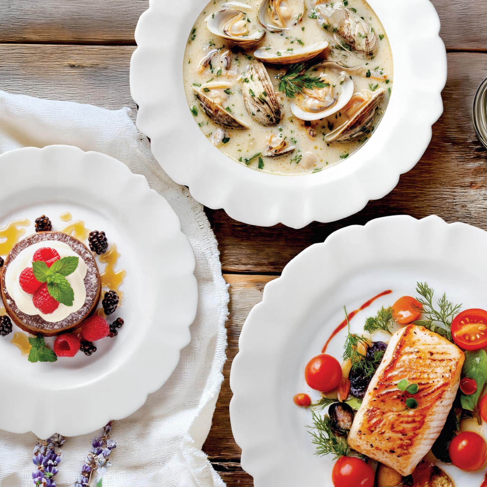 Tres platos de comida: sopa de almejas, pescado y postre de bayas.