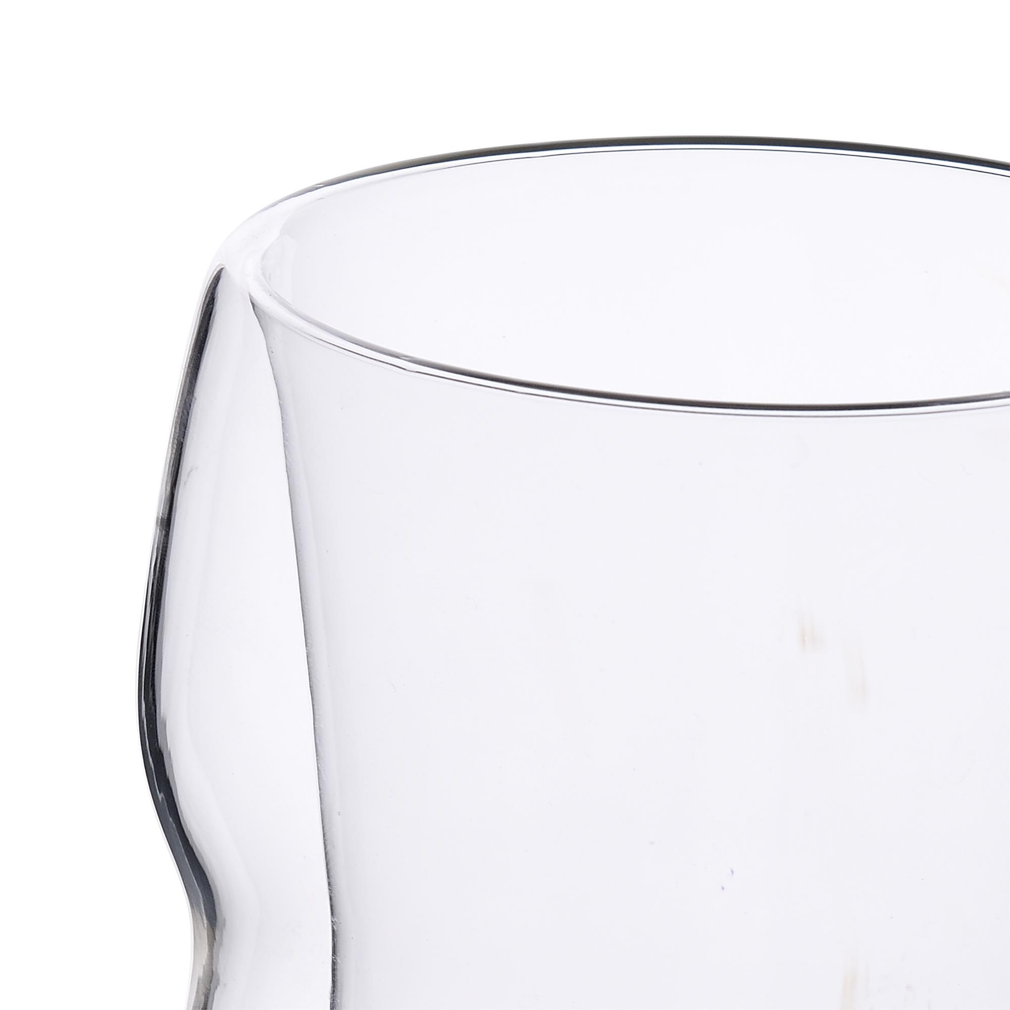 Primer plano de la parte superior de un vaso transparente y abombado sobre fondo blanco.