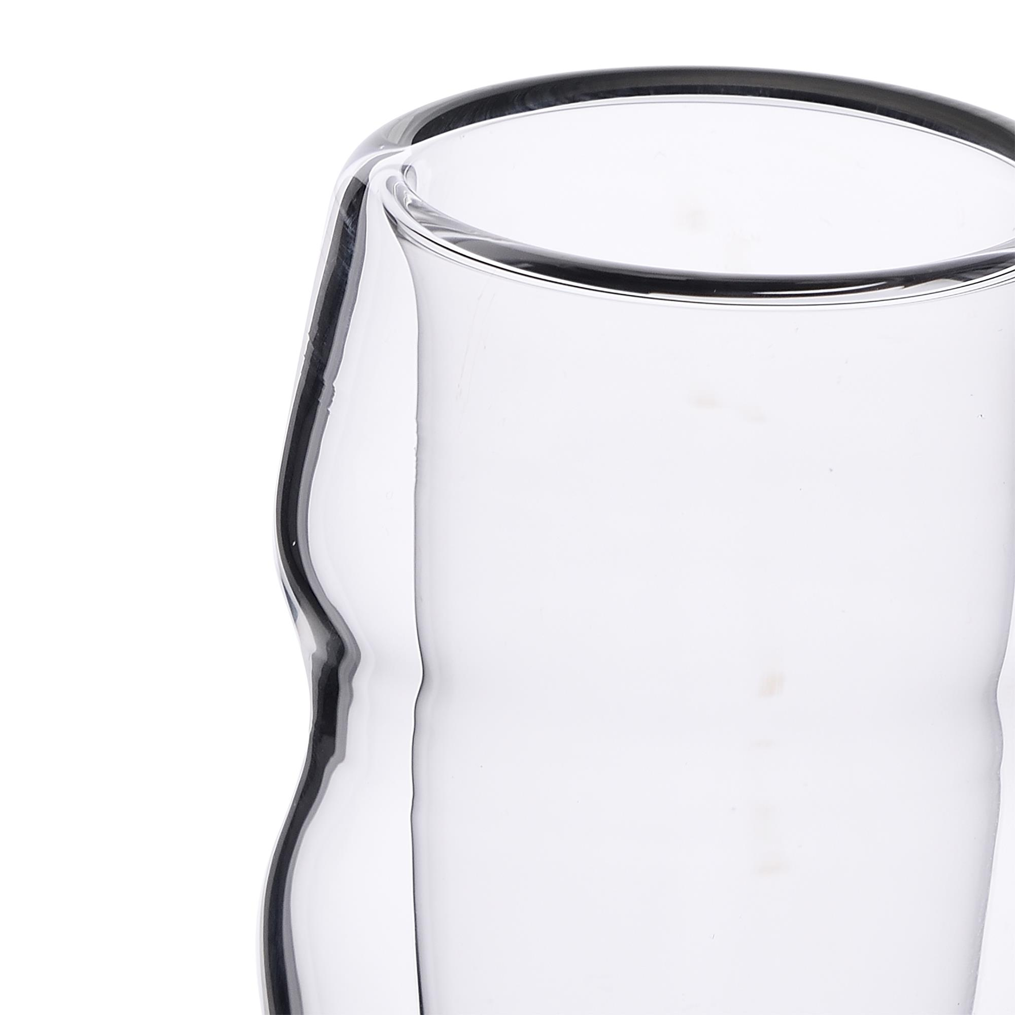 Primer plano de una taza de cristal de doble pared sobre fondo blanco.