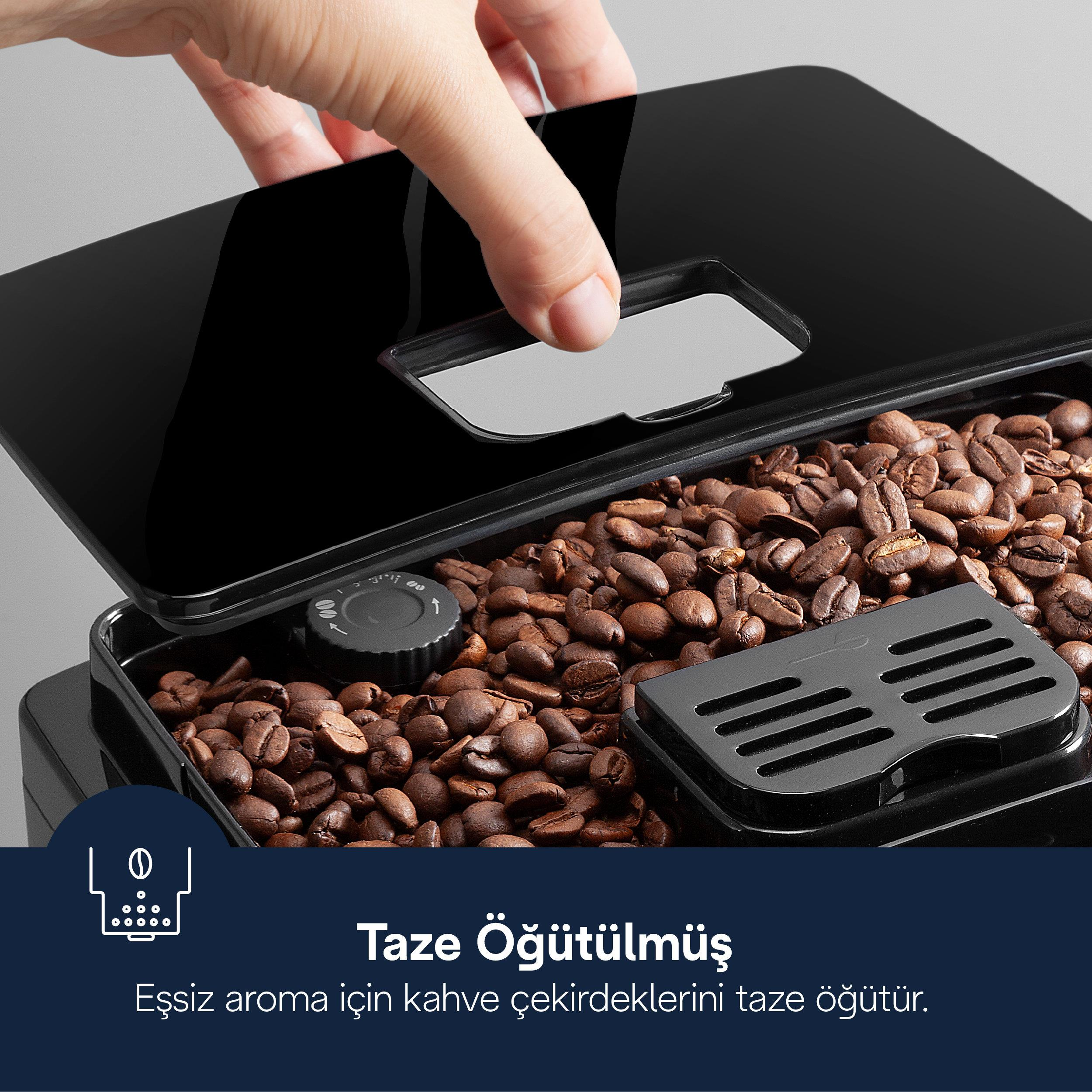 Bir el, kahve çekirdekleriyle dolu siyah bir haznenin kapağını açıyor.