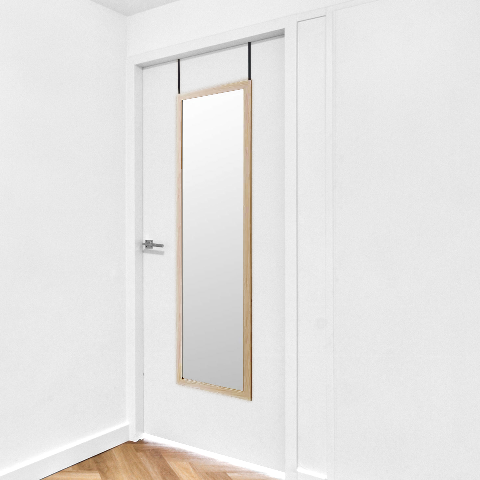 Un espejo estrecho con marco de madera cuelga de una puerta.