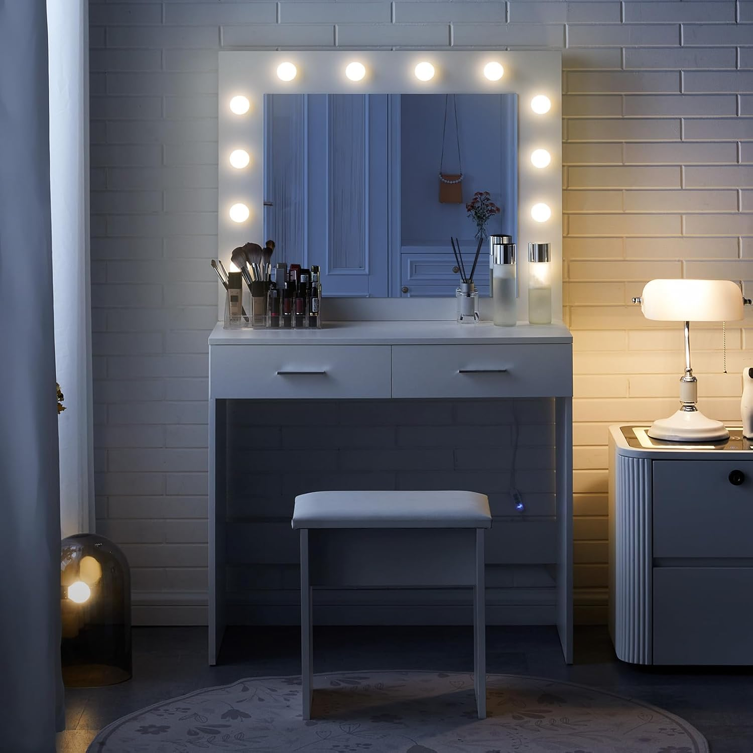 Tocador con espejo iluminado, maquillaje y taburete.