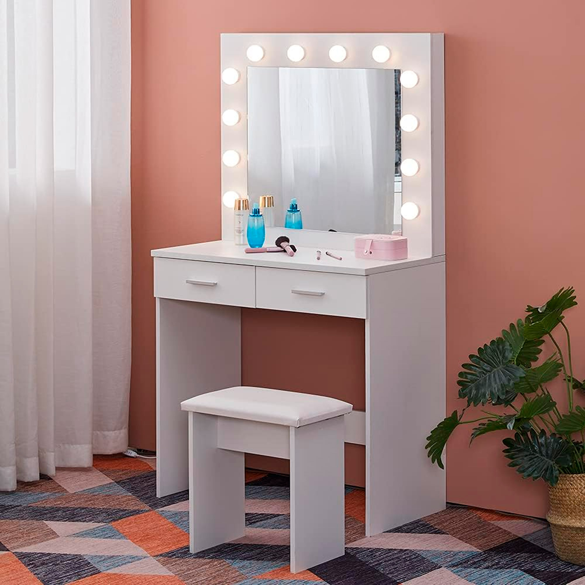 Tocador blanco con espejo iluminado, dos cajones, taburete y cosméticos.