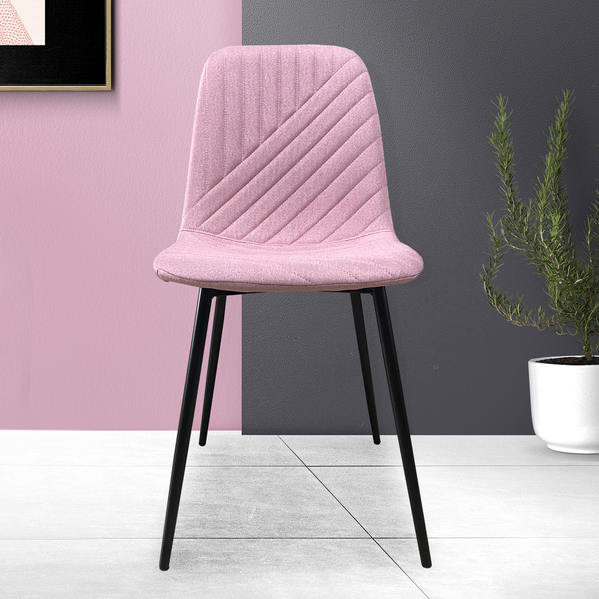 Una silla tapizada rosa con patas negras contra una pared.