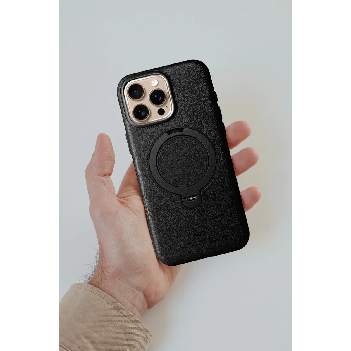 Bir el, halka tutuculu siyah bir iPhone tutuyor.