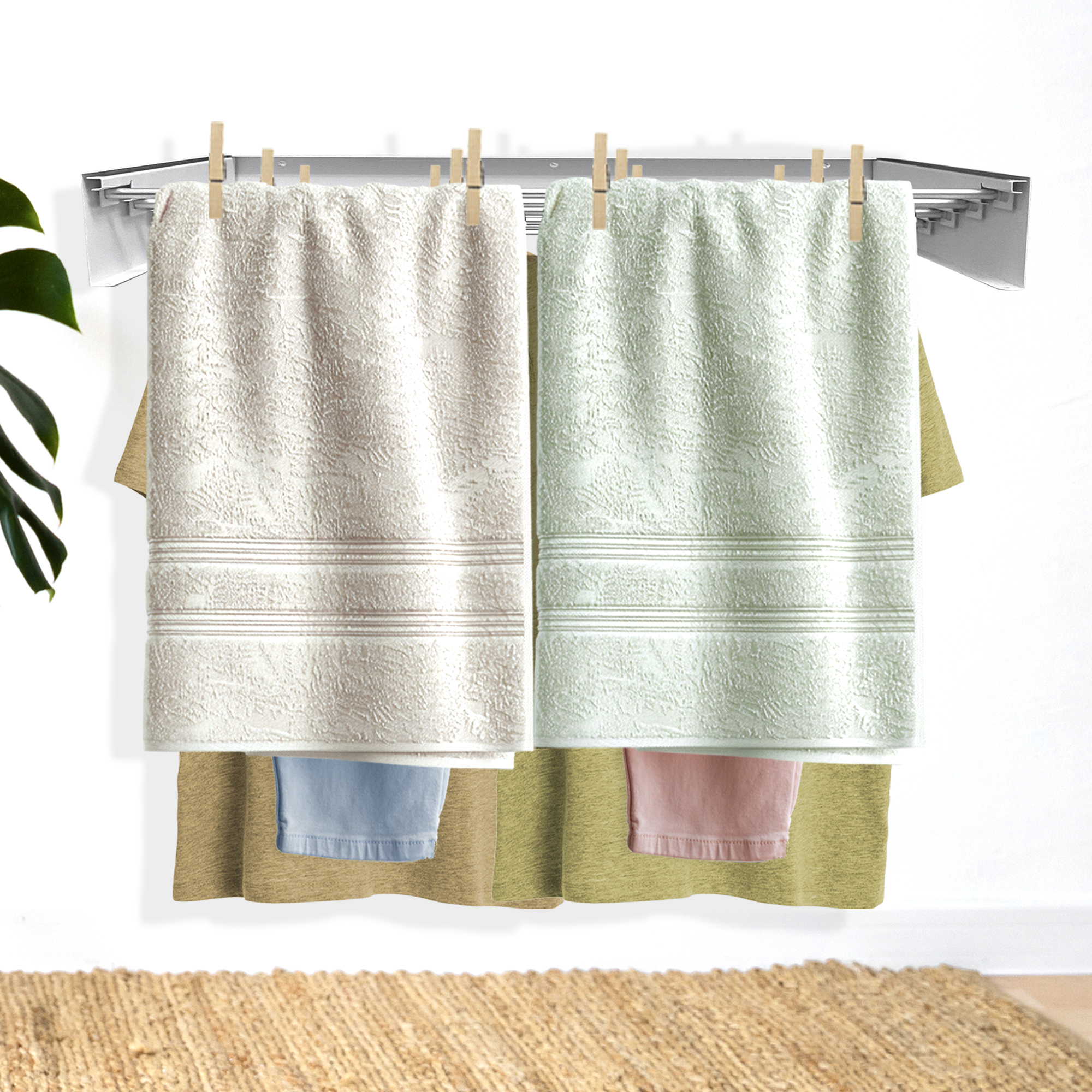 Dos toallas, beige y verde menta, cuelgan de un tendedero.