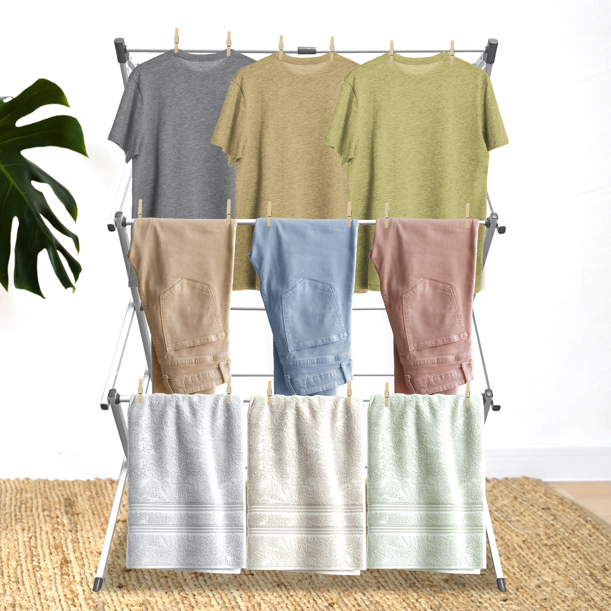 Ropa secándose en un tendedero: camisetas, pantalones y toallas de varios colores.