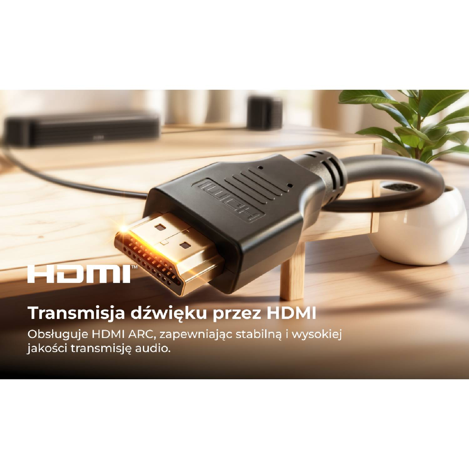 Czarny kabel HDMI ze złotą wtyczką leży na drewnianym stole.