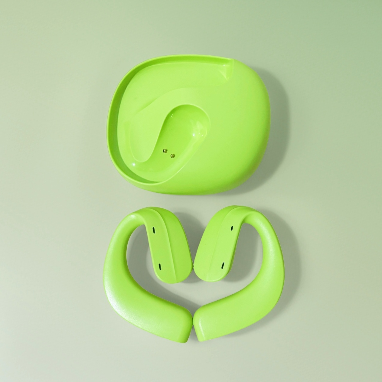 Dos piezas de plástico verde lima, una redonda, otra en forma de corazón, sobre fondo verde claro.