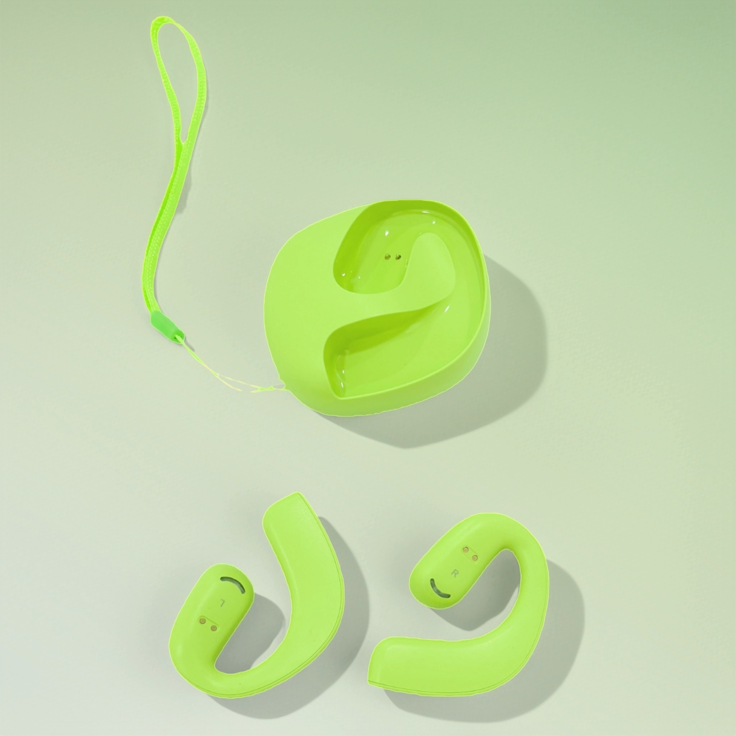 Auriculares verdes y estuche de carga con correa sobre fondo claro.