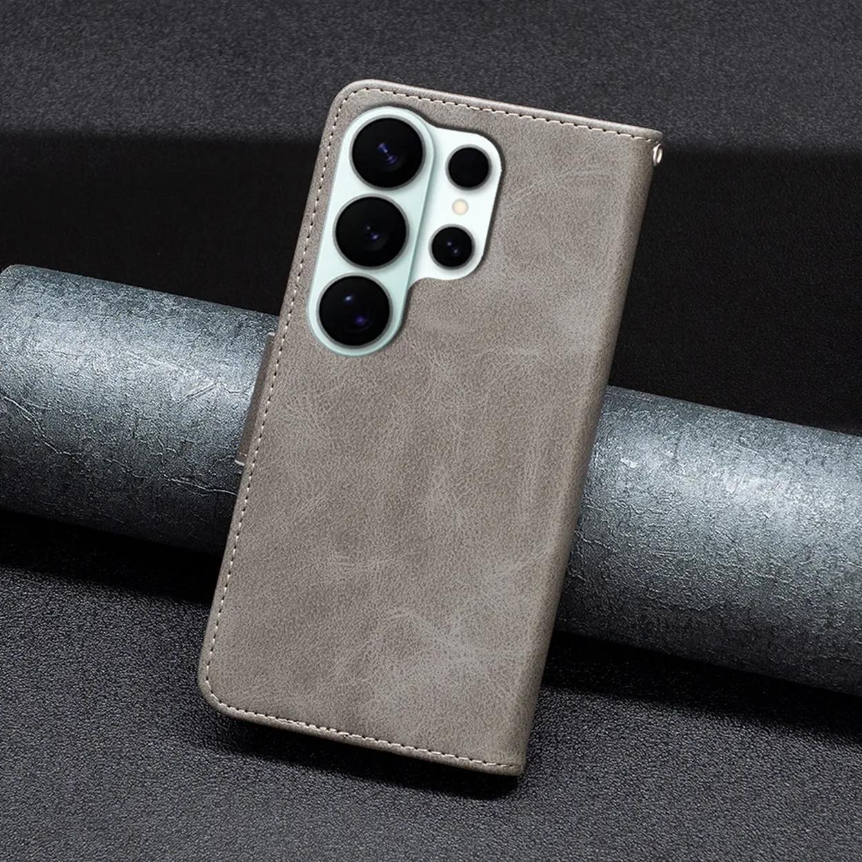 Coque de téléphone grise avec quatre objectifs de caméra sur une surface sombre.