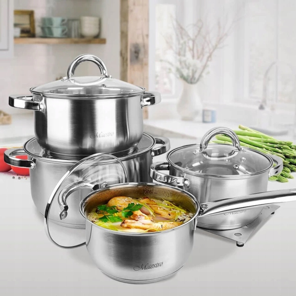 Stalowe garnki z szklanymi pokrywkami i jeden garnek z jedzeniem.