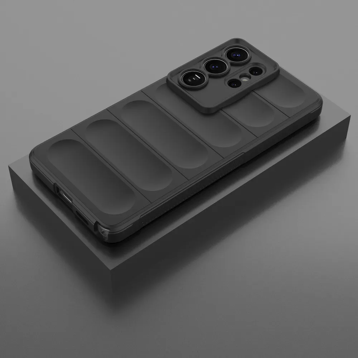 Een zwarte telefoon met cameralensmodule rust op een grijs voetstuk.