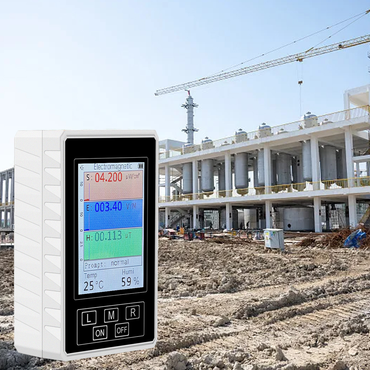 Ein EMF-Messgerät zeigt Werte an, im Hintergrund eine Baustelle mit Kran und Gebäuden.
