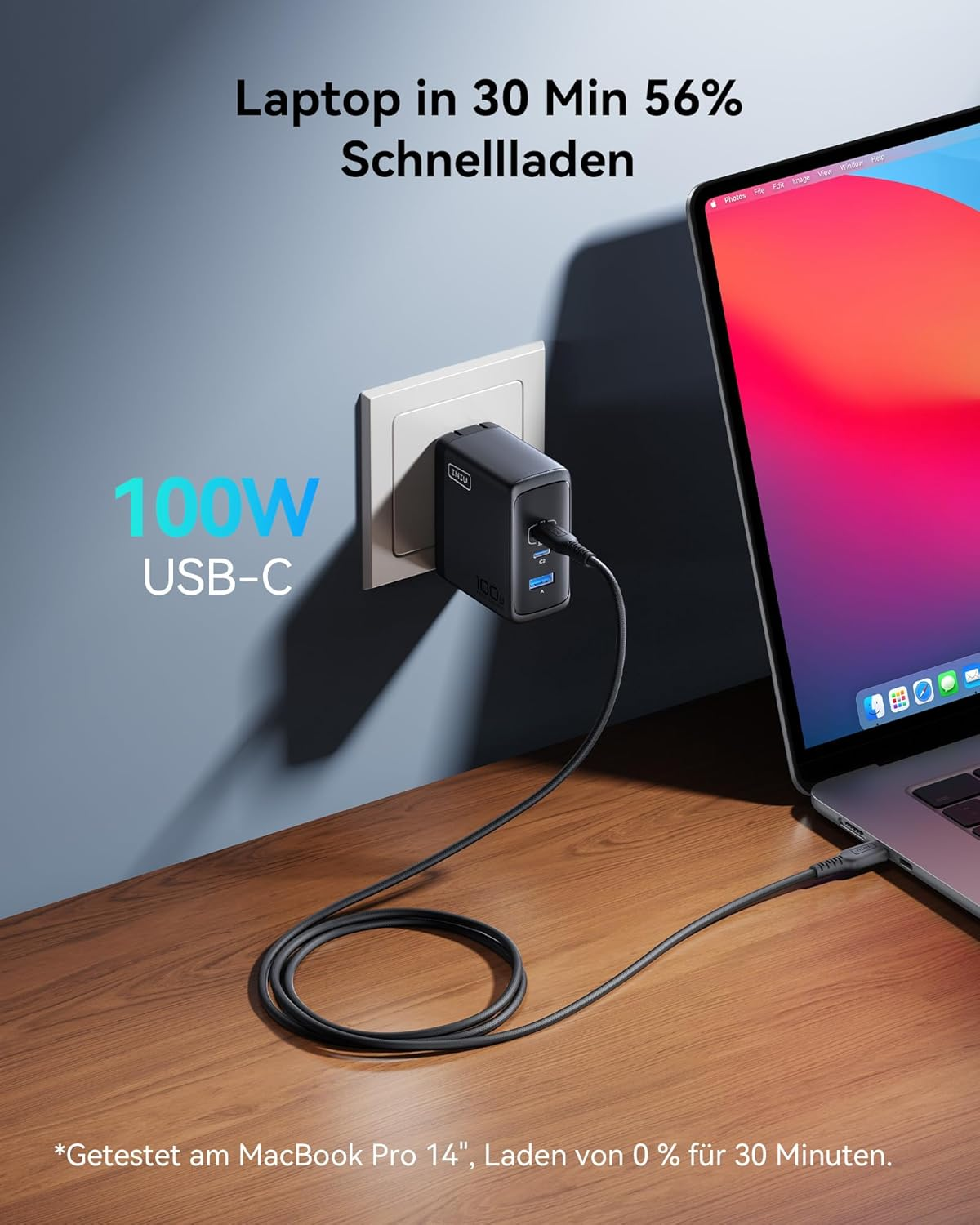 Czarna ładowarka USB-C o mocy 100W jest podłączona i ładuje laptopa.
