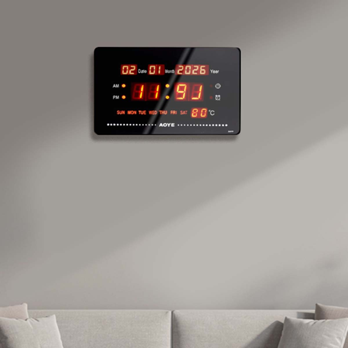 Eine digitale Wanduhr zeigt Datum, Uhrzeit, Tag und Temperatur an.