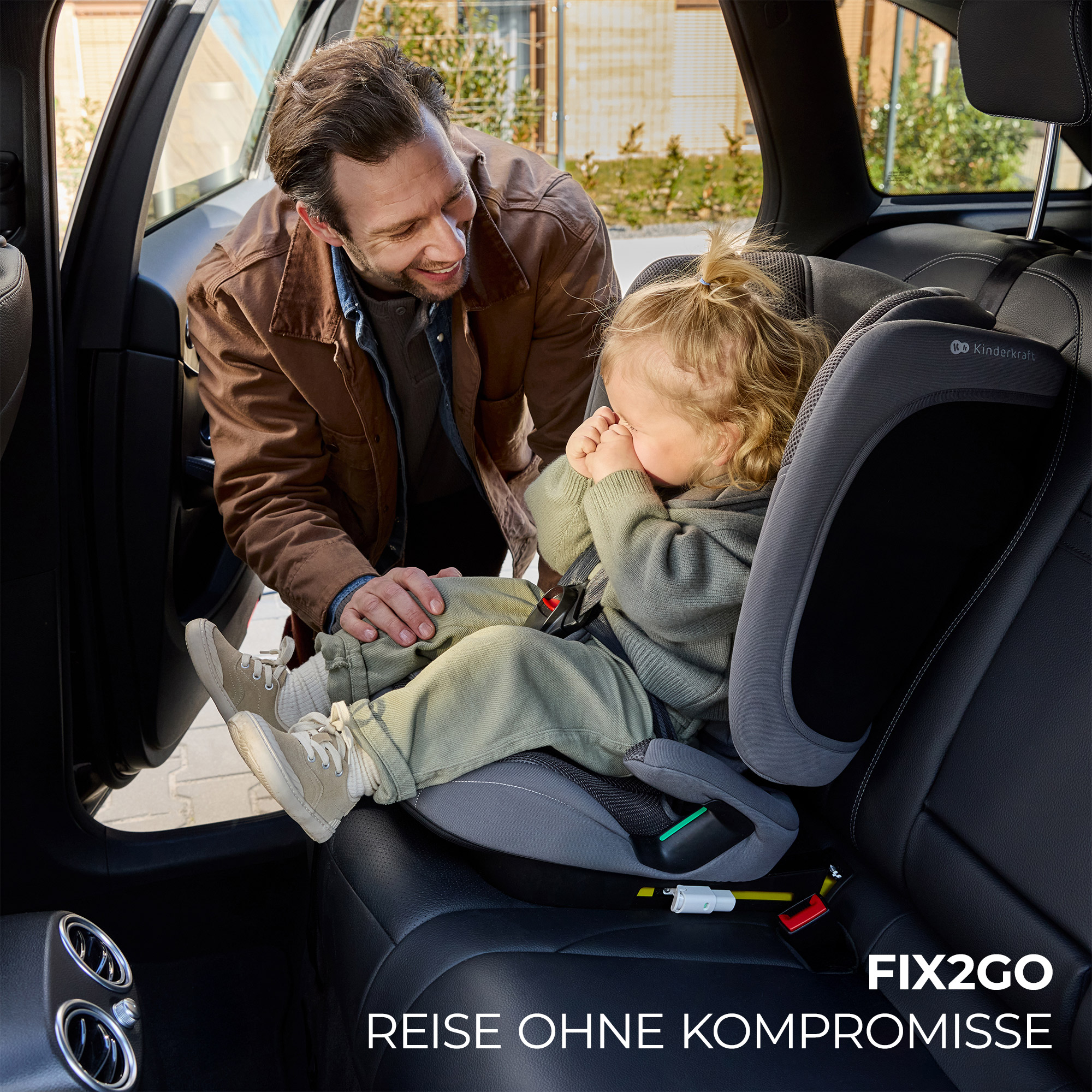Mann beugt sich über ein Kind im Kindersitz im Auto.