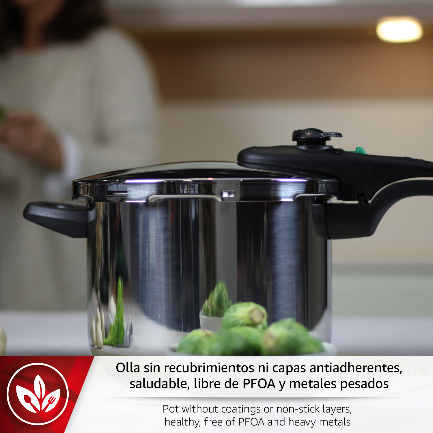Olla de acero inoxidable con asa y válvula, con verduras verdes cerca.