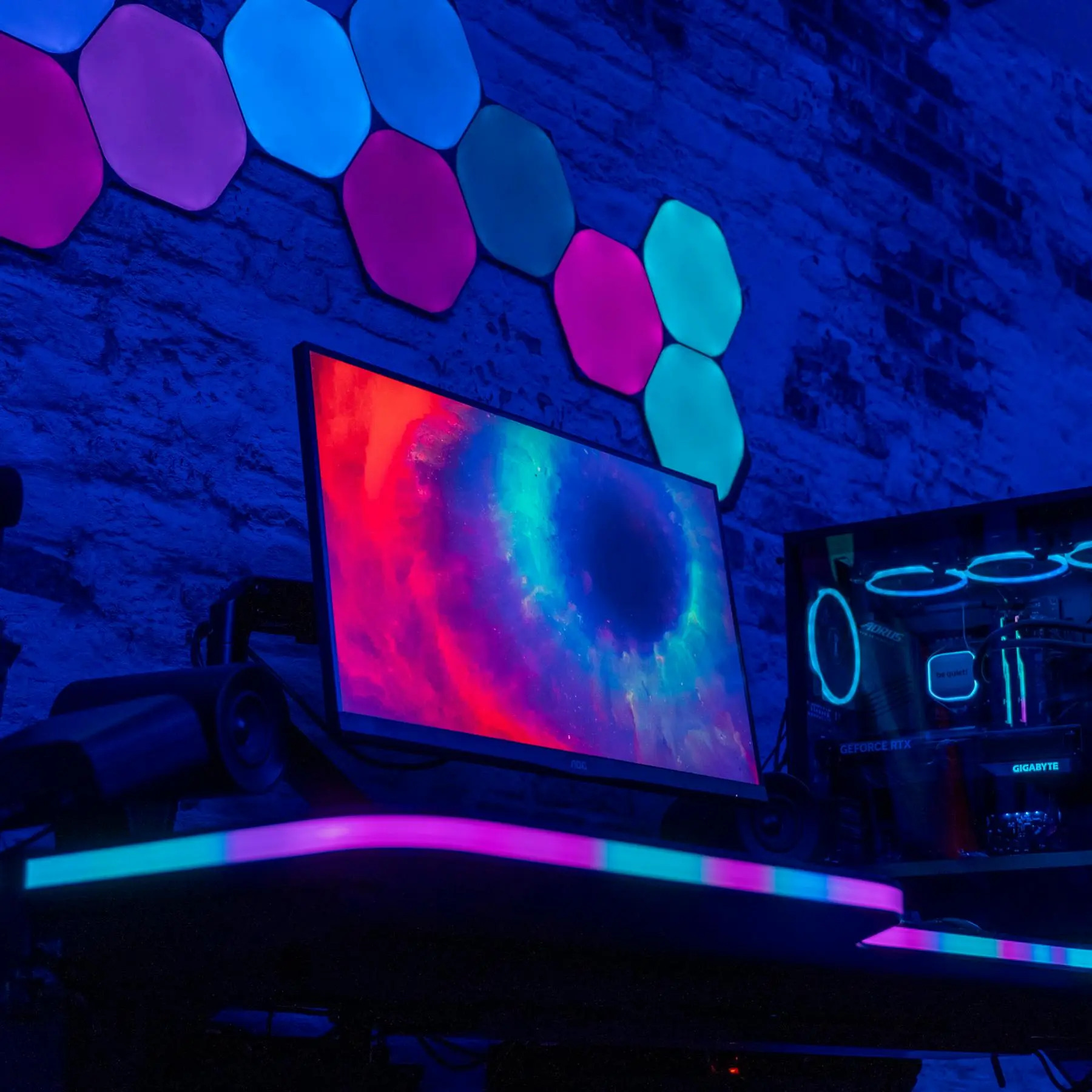 Ein Gaming-PC mit RGB-Beleuchtung und einem Monitor mit Weltraumhintergrund.