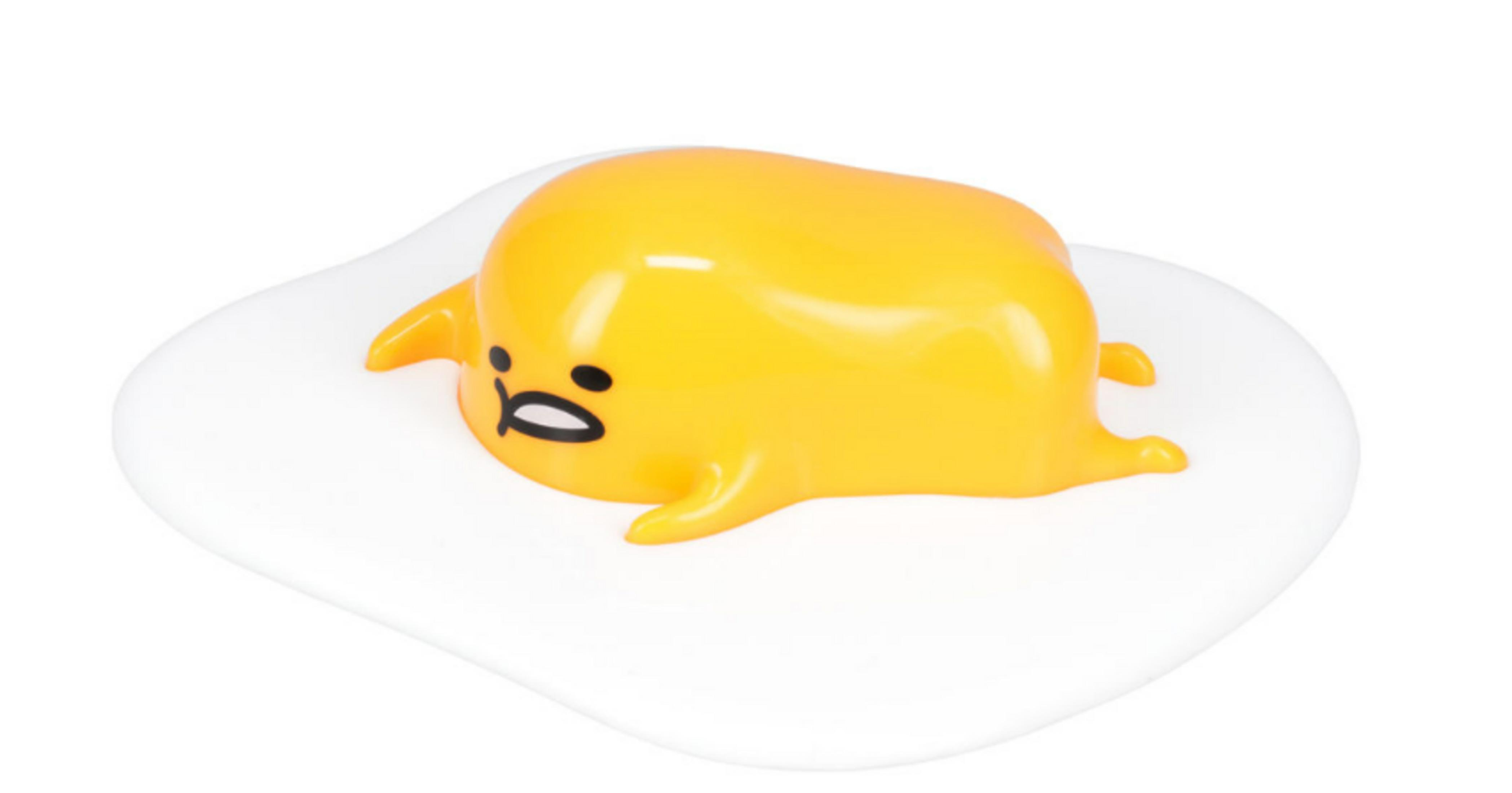 Eine gelbe Figur mit Gesicht liegt auf einem weißen Eiweiß.
