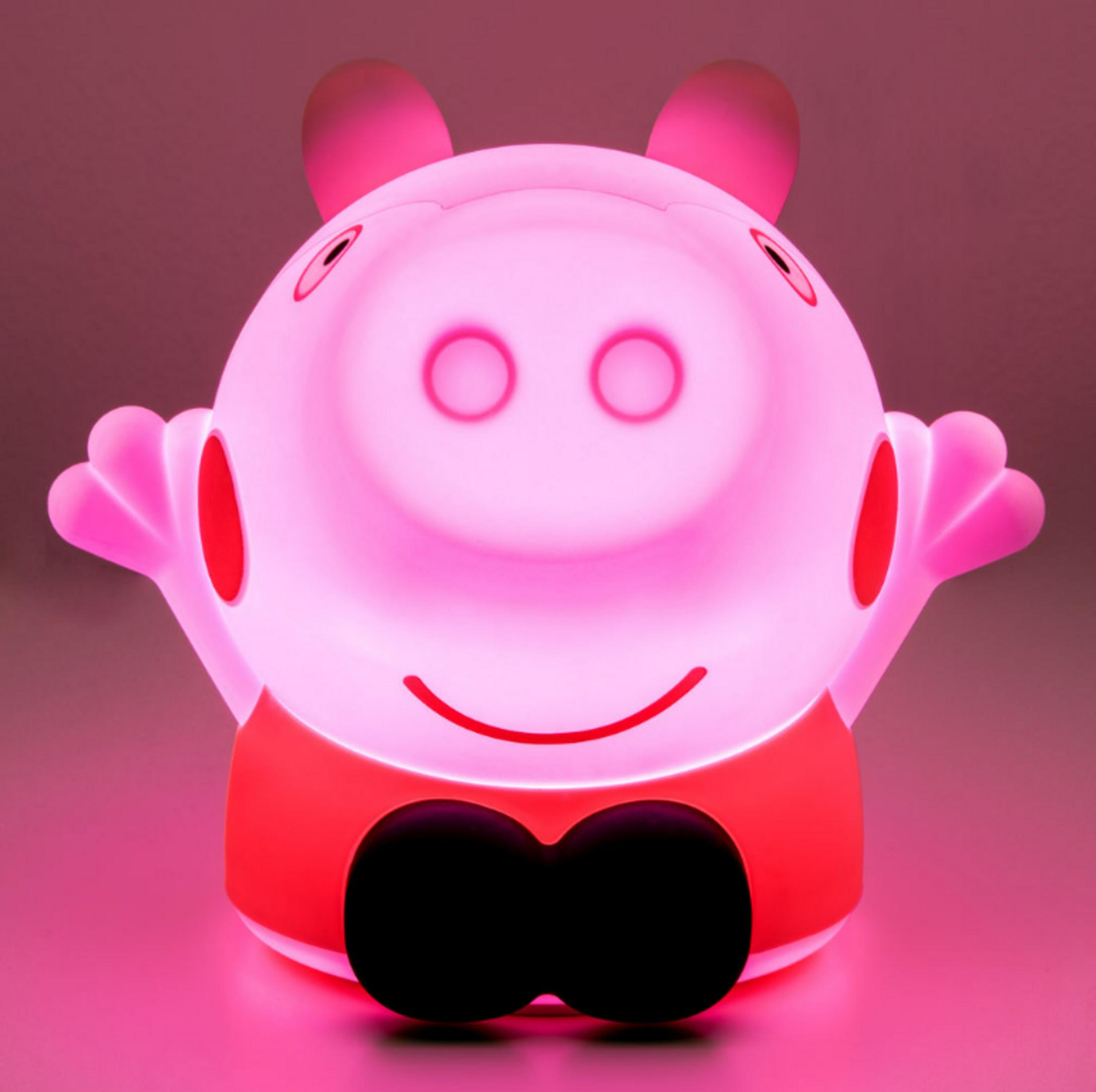 Świecąca różowa lampka Peppa Pig z czarnymi oczami i uśmiechem.
