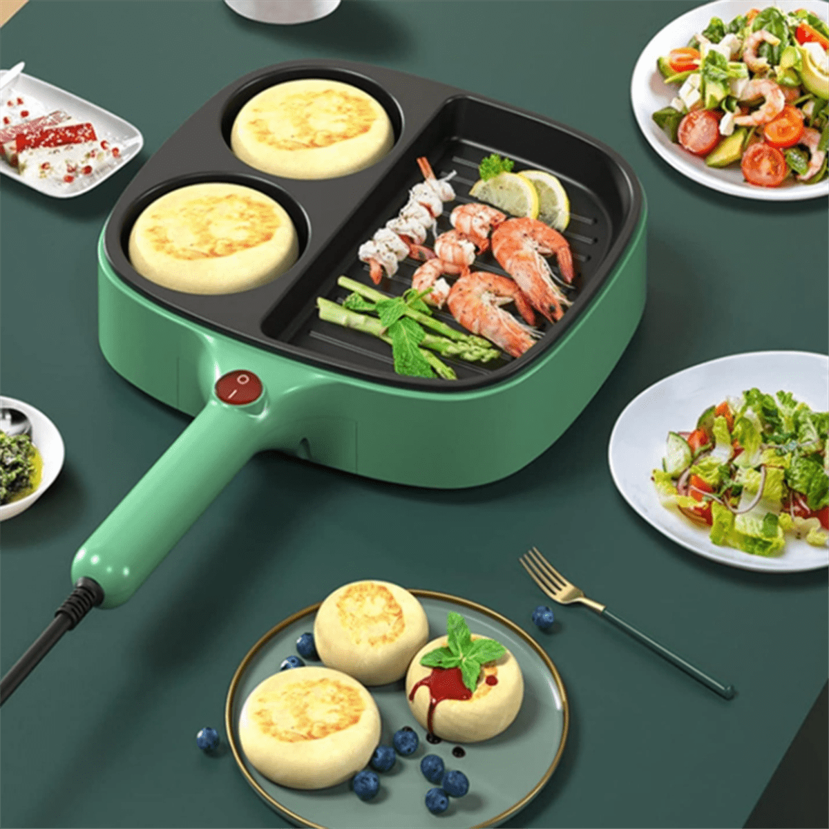 Grüne Kontaktgrillplatte mit Pfannkuchen, Garnelen und Spargel. Daneben Salate und Beeren-Dessert.