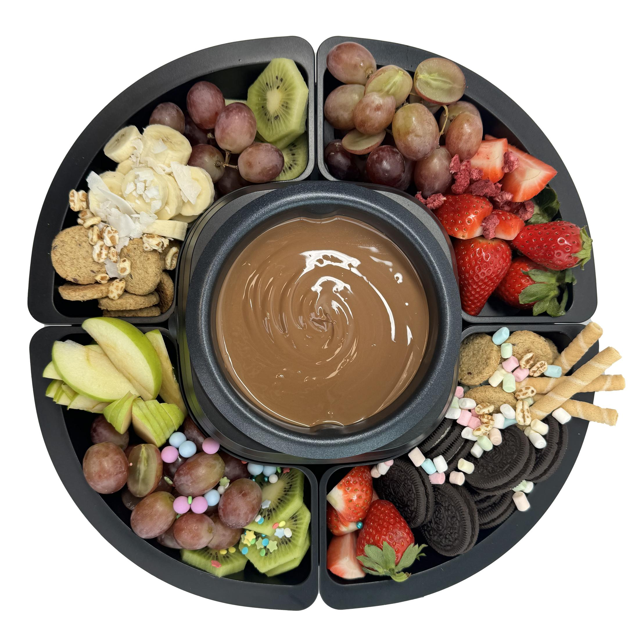 Piatto da fonduta al cioccolato con frutta, biscotti e marshmallow.