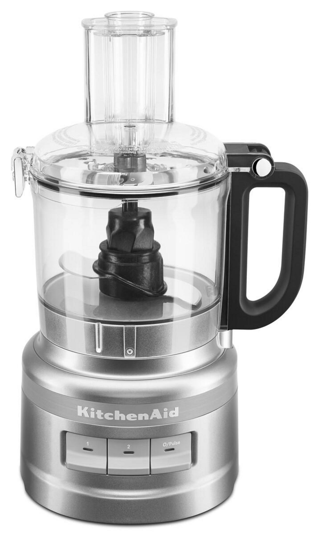 Un robot da cucina KitchenAid argento con ciotola trasparente e manico nero.
