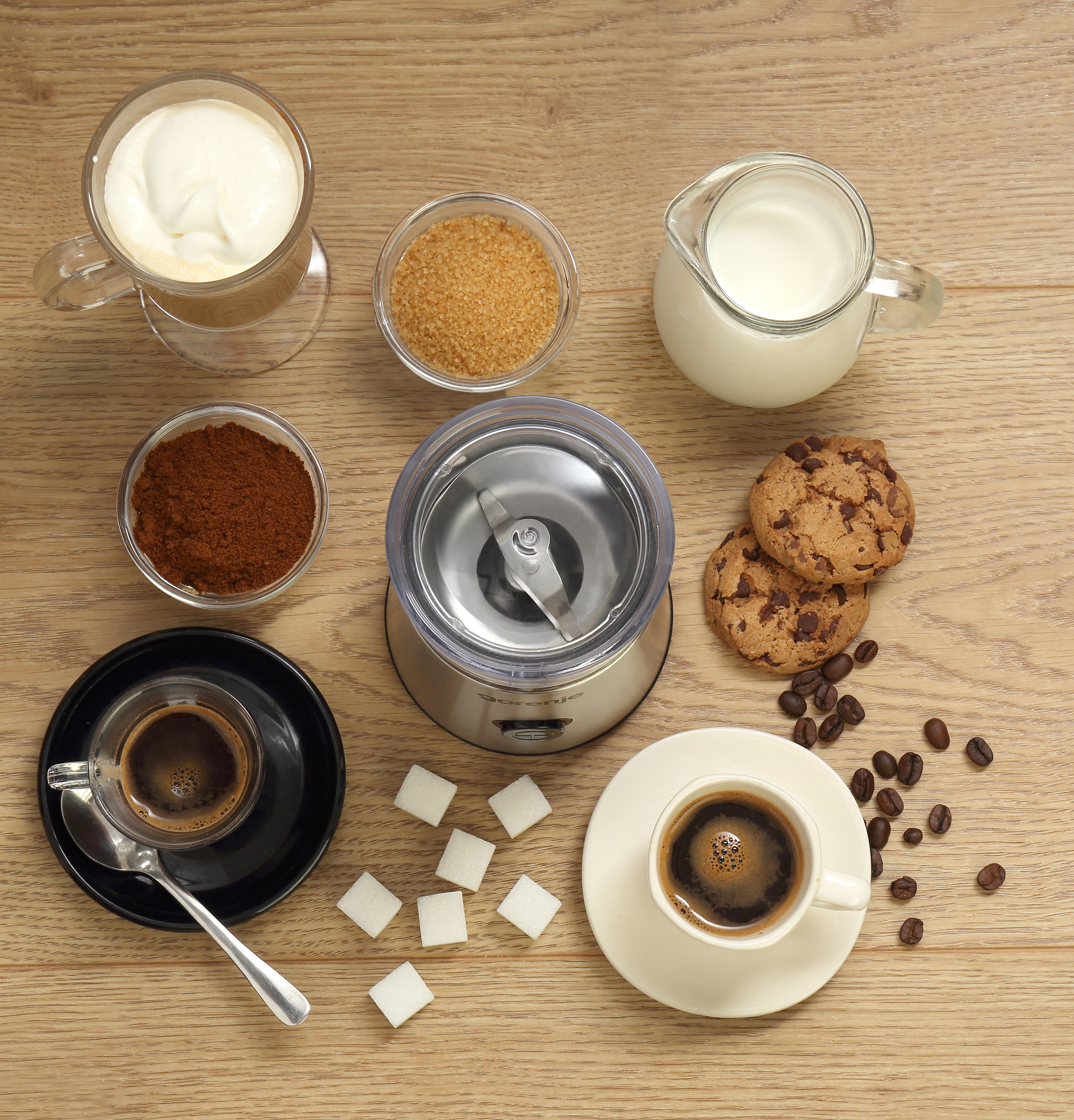 Preparazione caffè con macinacaffè, zucchero, latte, biscotti e caffè.