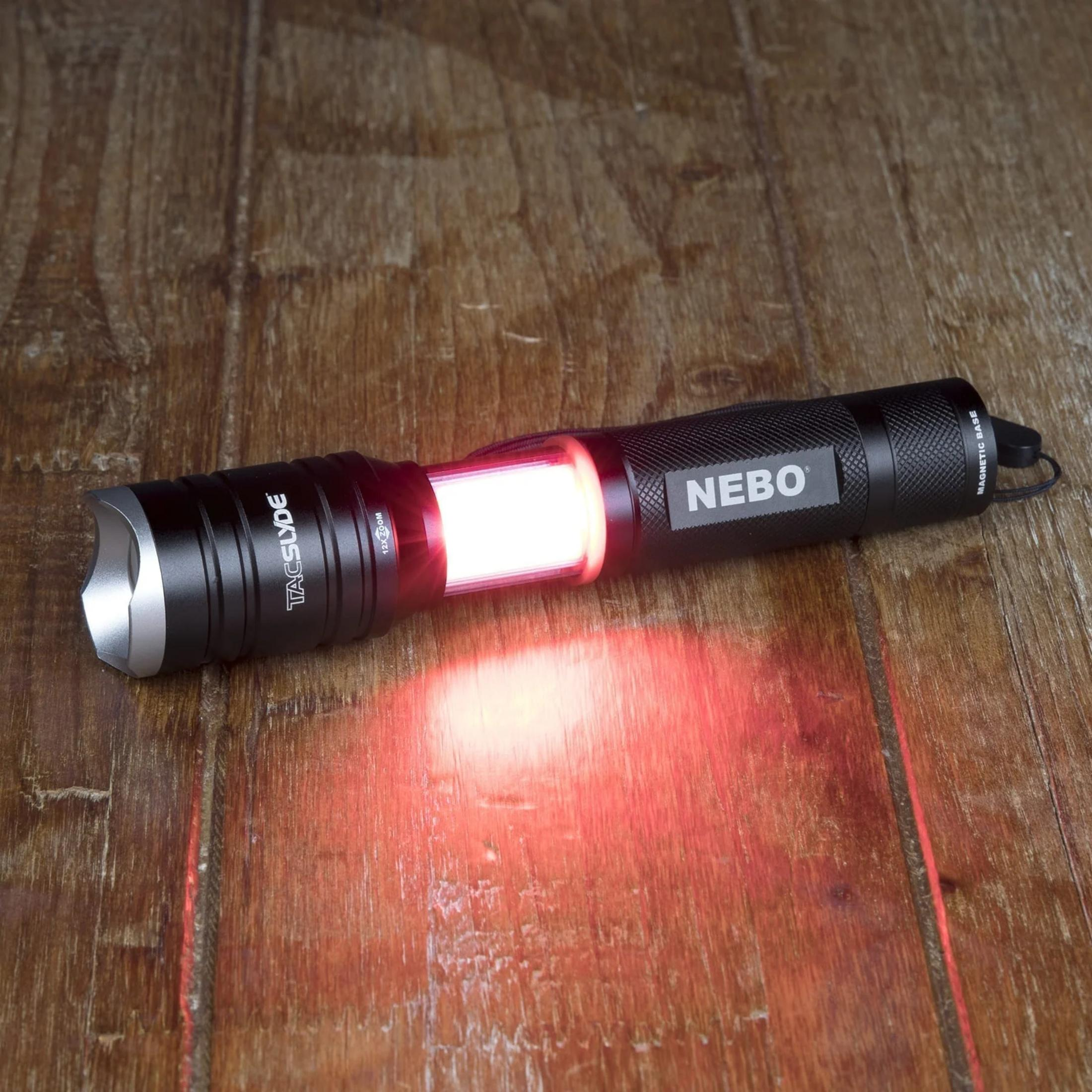 Torcia nera con luce rossa su superficie in legno. Logo NEBO visibile.