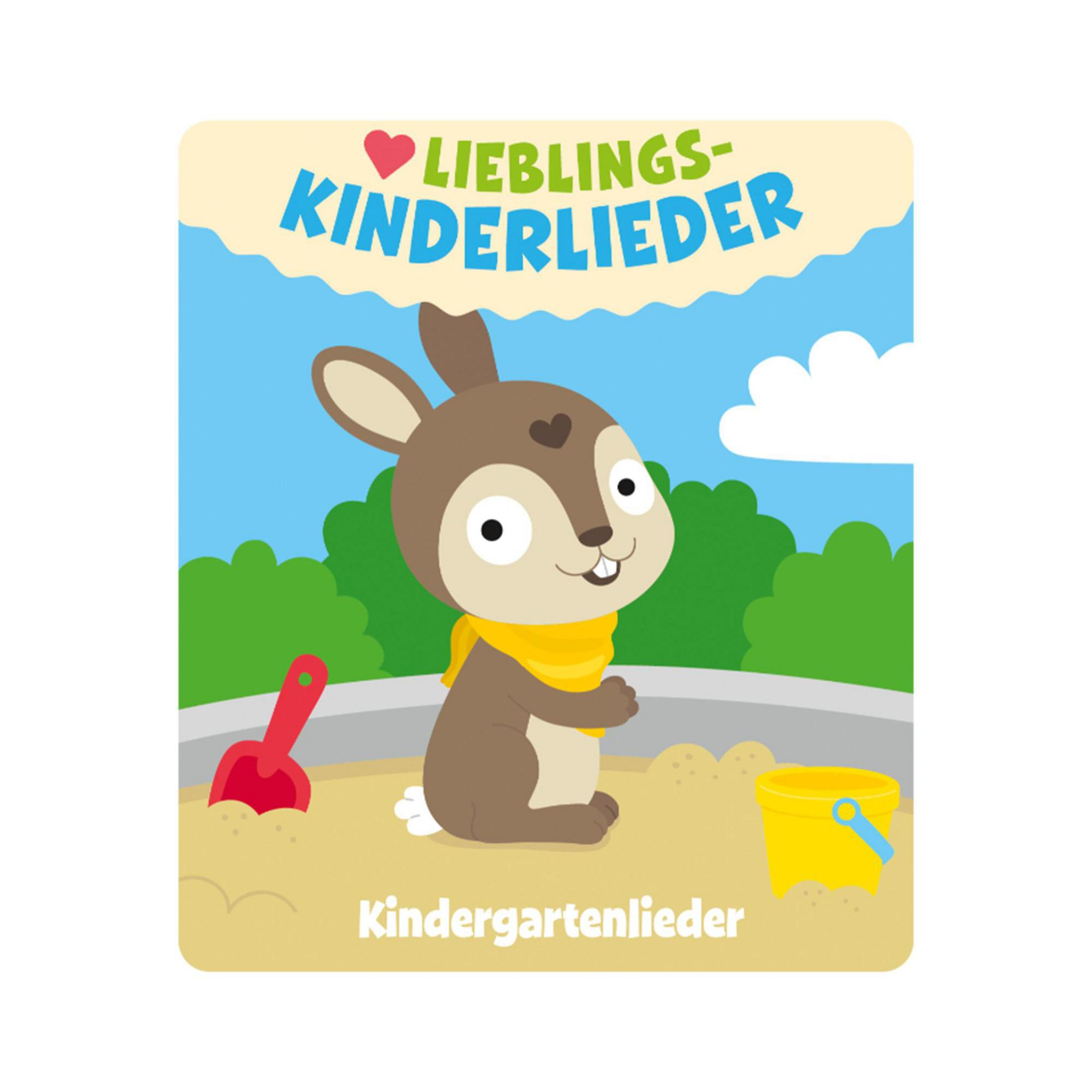 Ein Hase mit gelbem Schal sitzt im Sand neben einer Schaufel und einem Eimer.