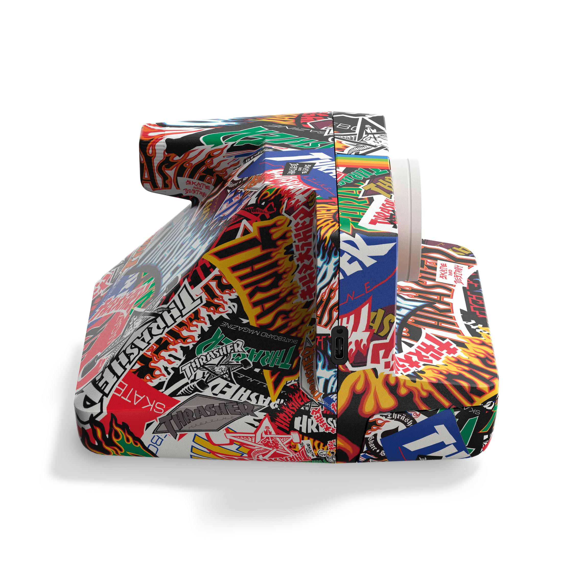 Una fotocamera coperta da adesivi colorati di marchi di skate come Thrasher.