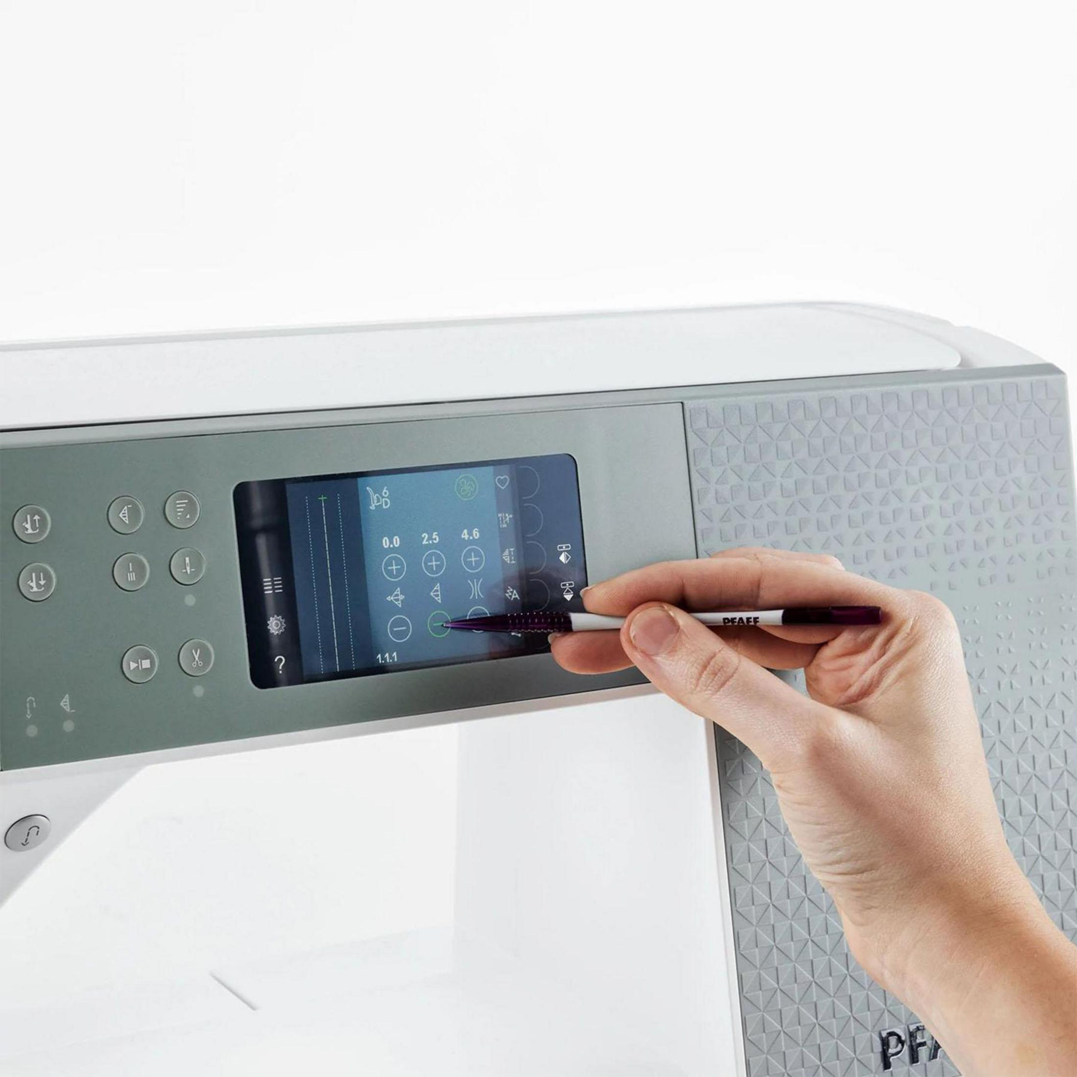 Ein Finger berührt den Touchscreen einer Nähmaschine mit Symbolen.