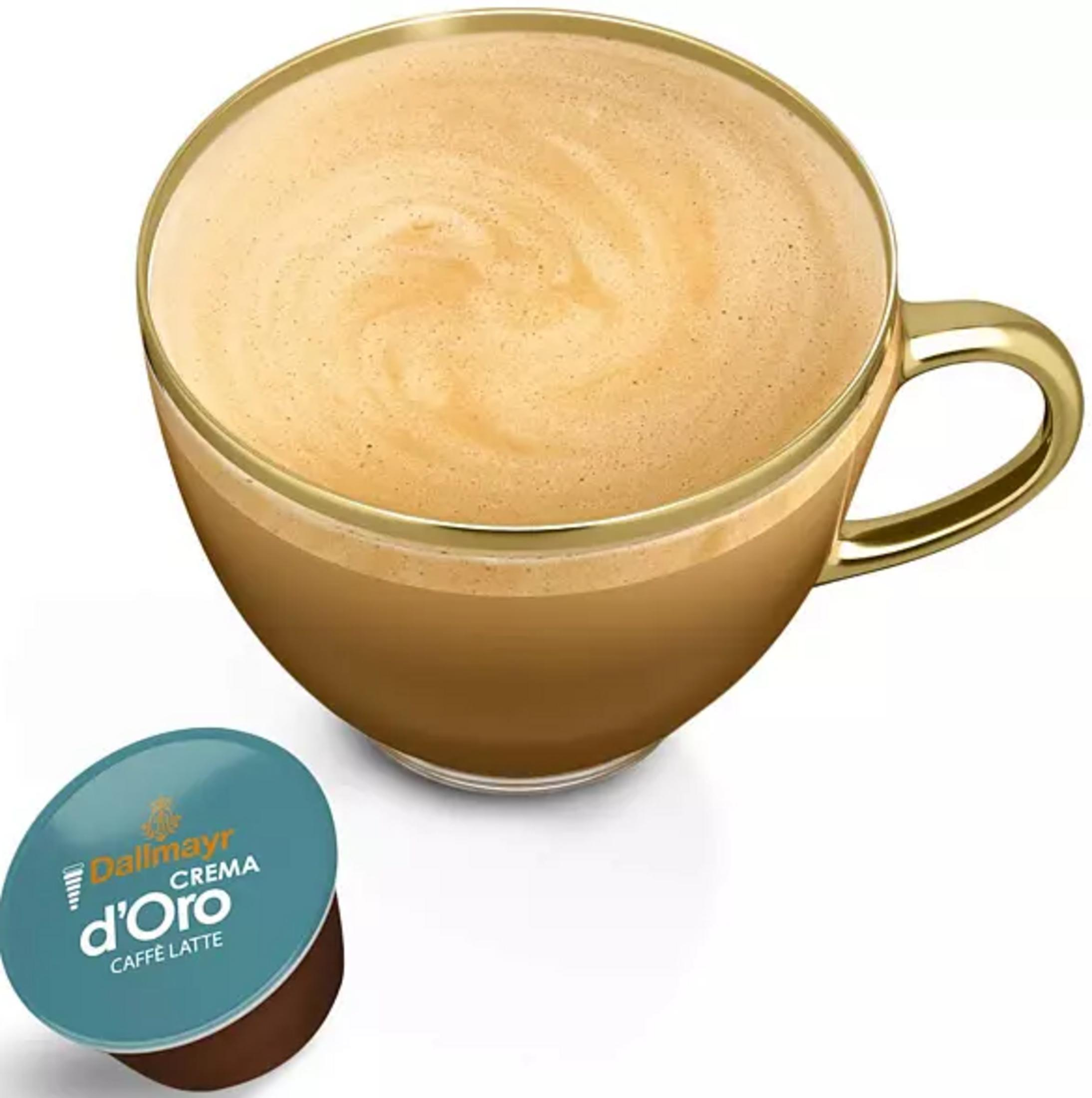 Eine Dallmayr Crema d'Oro Kaffeekapsel neben einer Tasse Kaffee Latte.