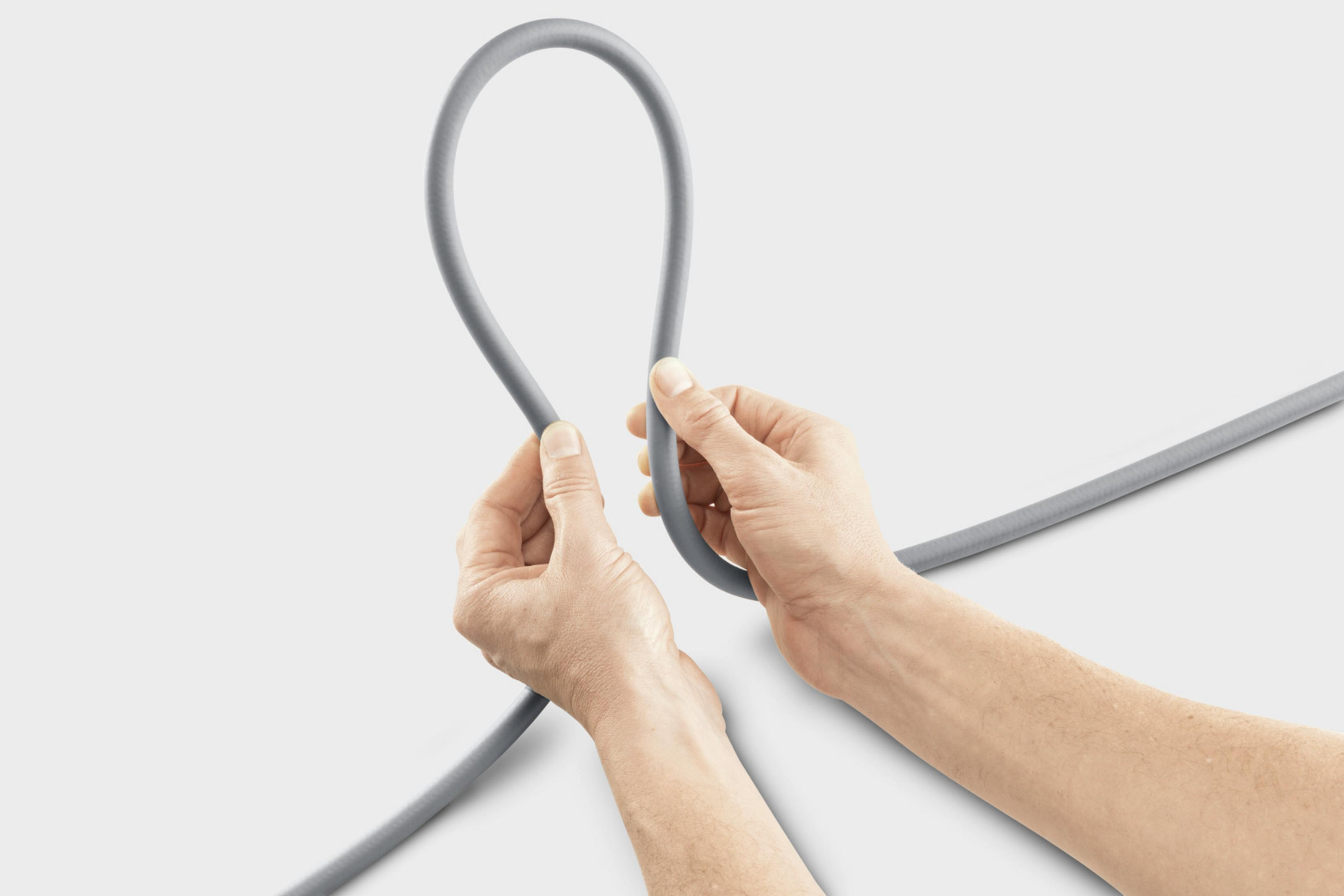Graues Kabel wird von Händen zu einer Schlaufe geformt.