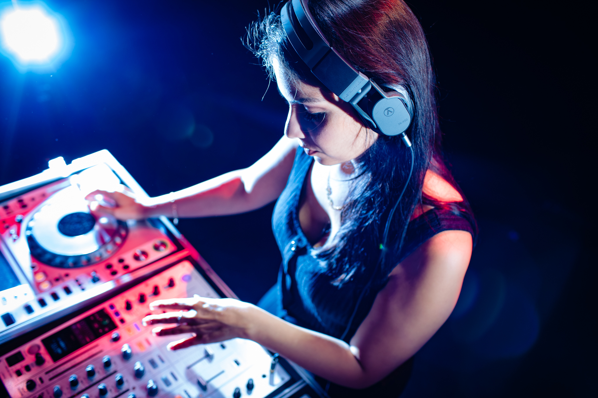 Une DJeuse avec un casque joue de la musique sur une console.
