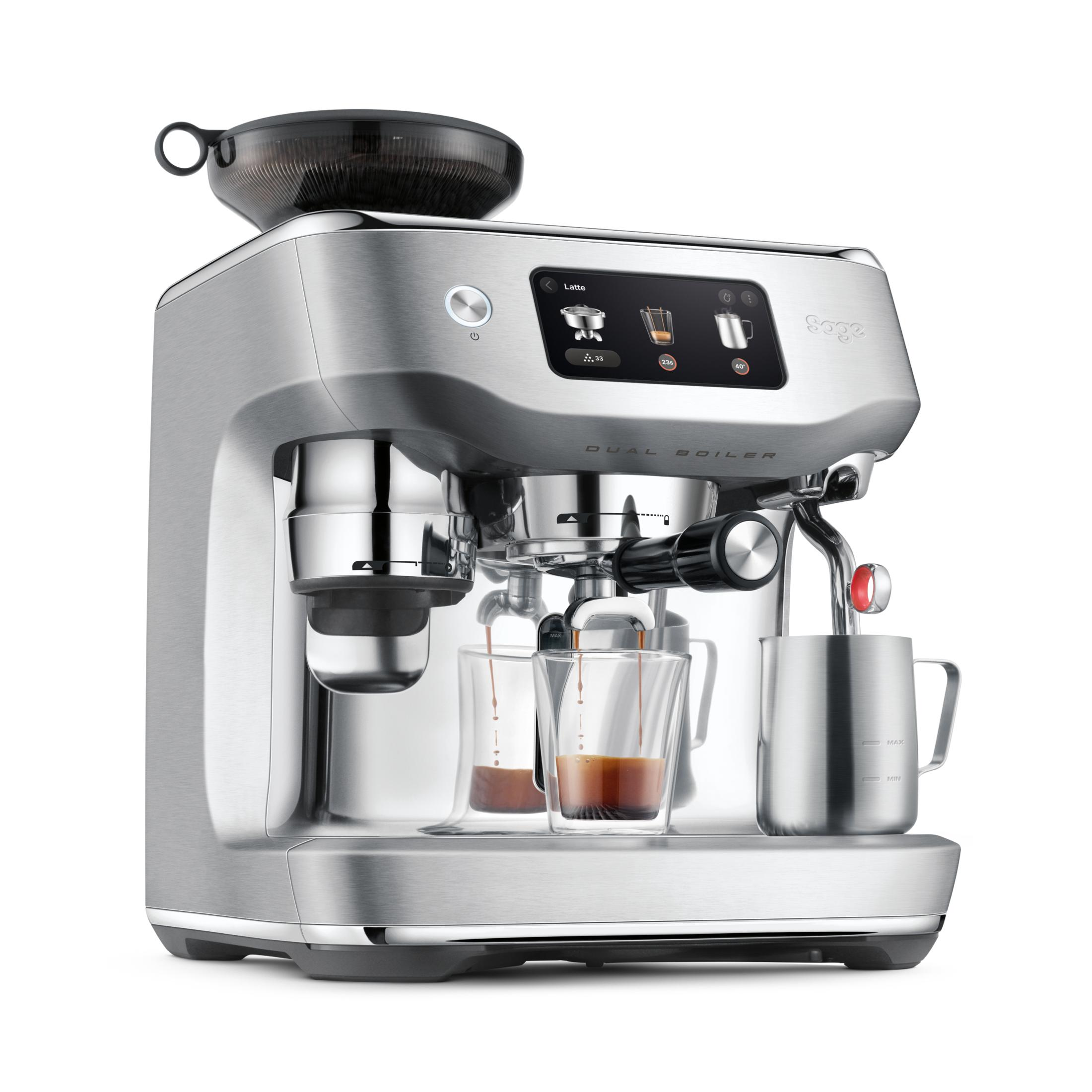 Silberne Espressomaschine brüht Kaffee in zwei Gläser; daneben Milchkännchen.