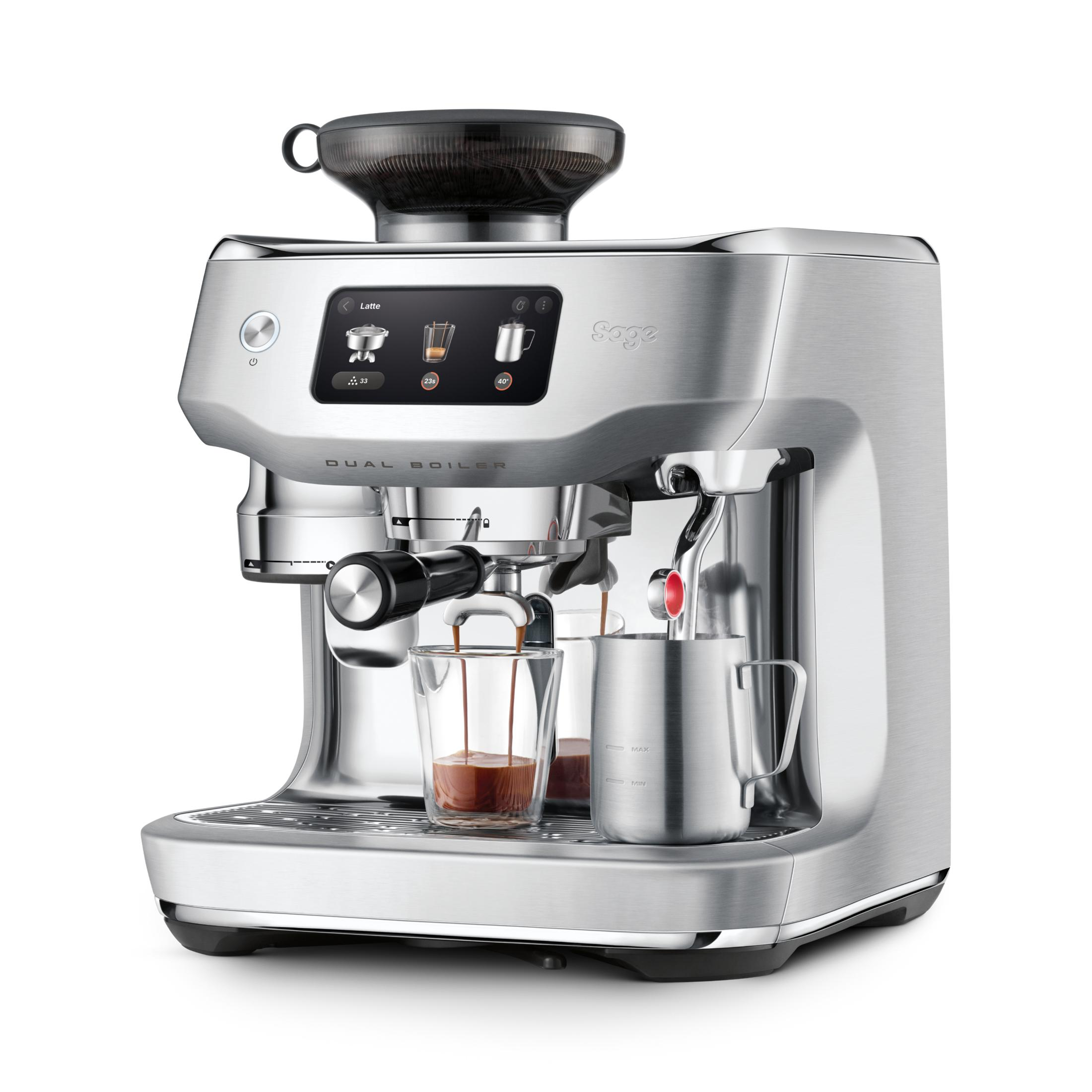 Eine silberne Espressomaschine mit Siebträger, Milchkanne und Glas. Espresso fließt in das Glas.