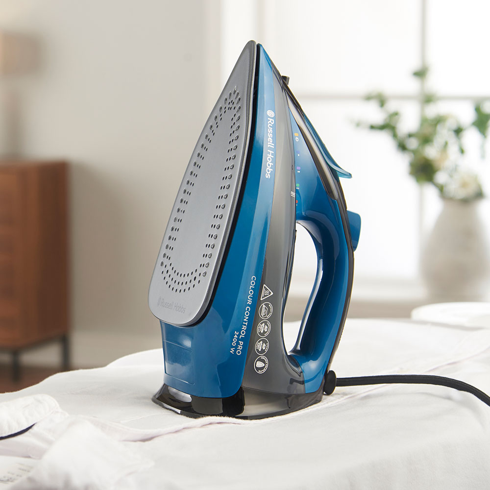 Ein blauer Russell Hobbs Dampfbügeleisen steht auf einem weißen Hemd.