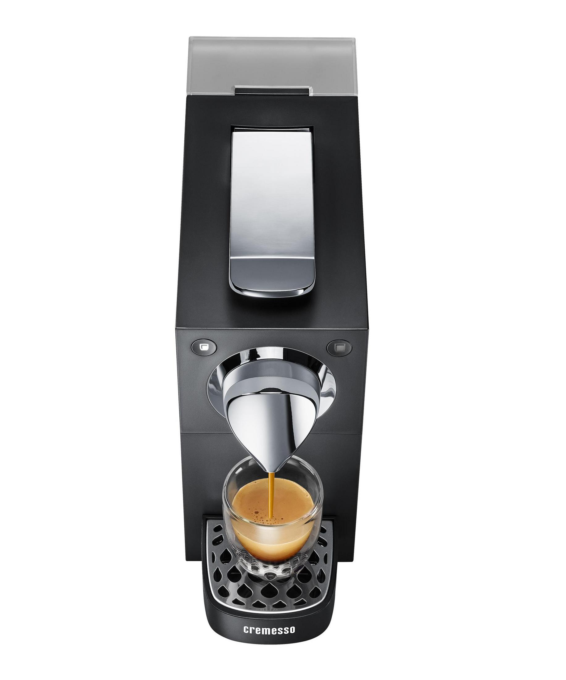 Eine schwarze Kaffeemaschine brüht Espresso in ein Glas.