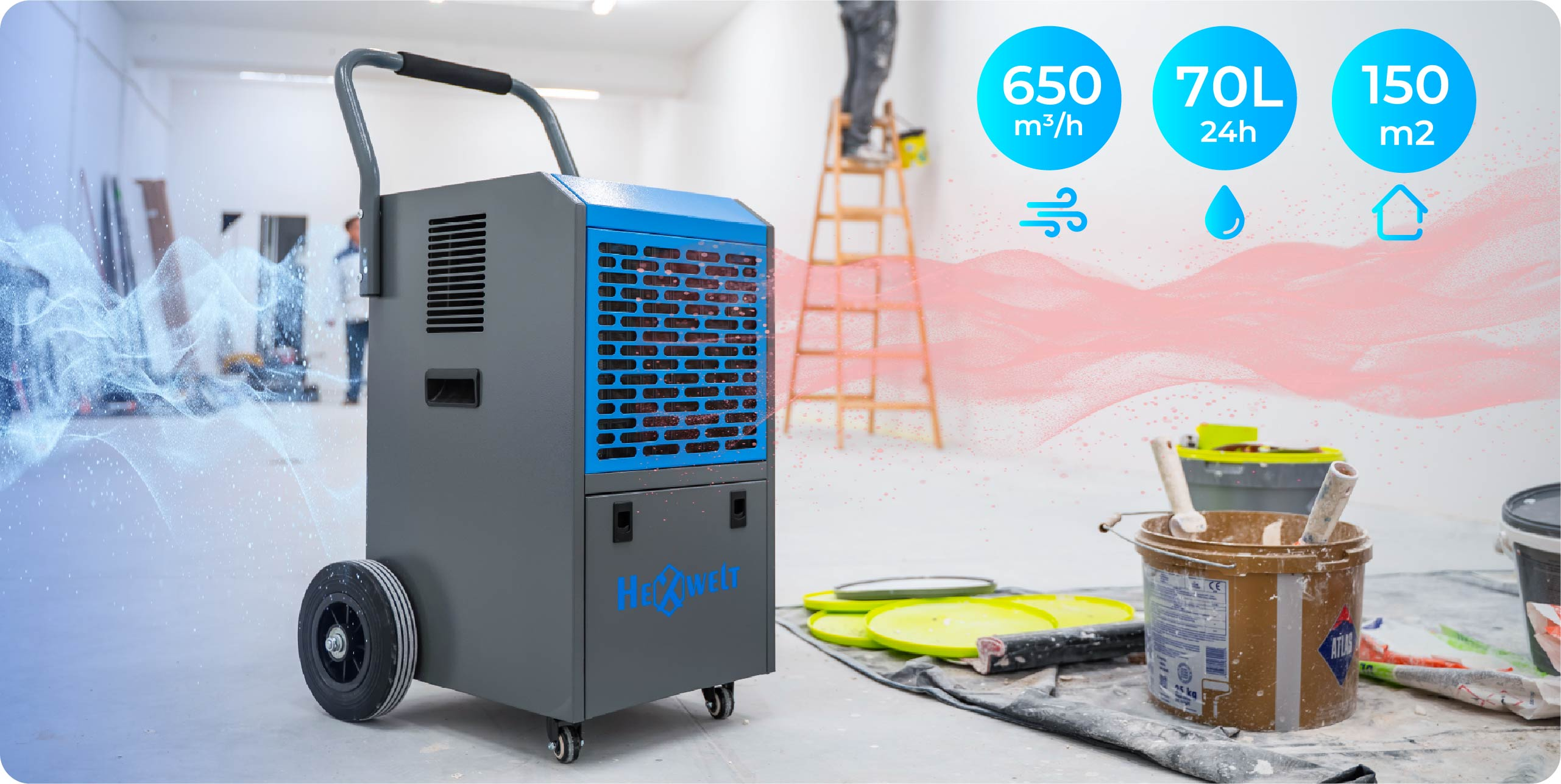 Szary osuszacz powietrza z niebieskimi akcentami na kółkach. Artykuły malarskie w pobliżu.