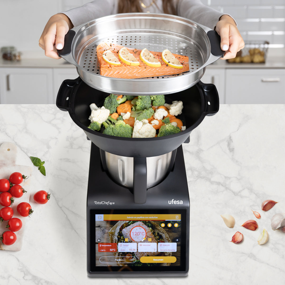 Un electrodoméstico con filete de salmón y rodajas de limón sobre verduras al vapor.