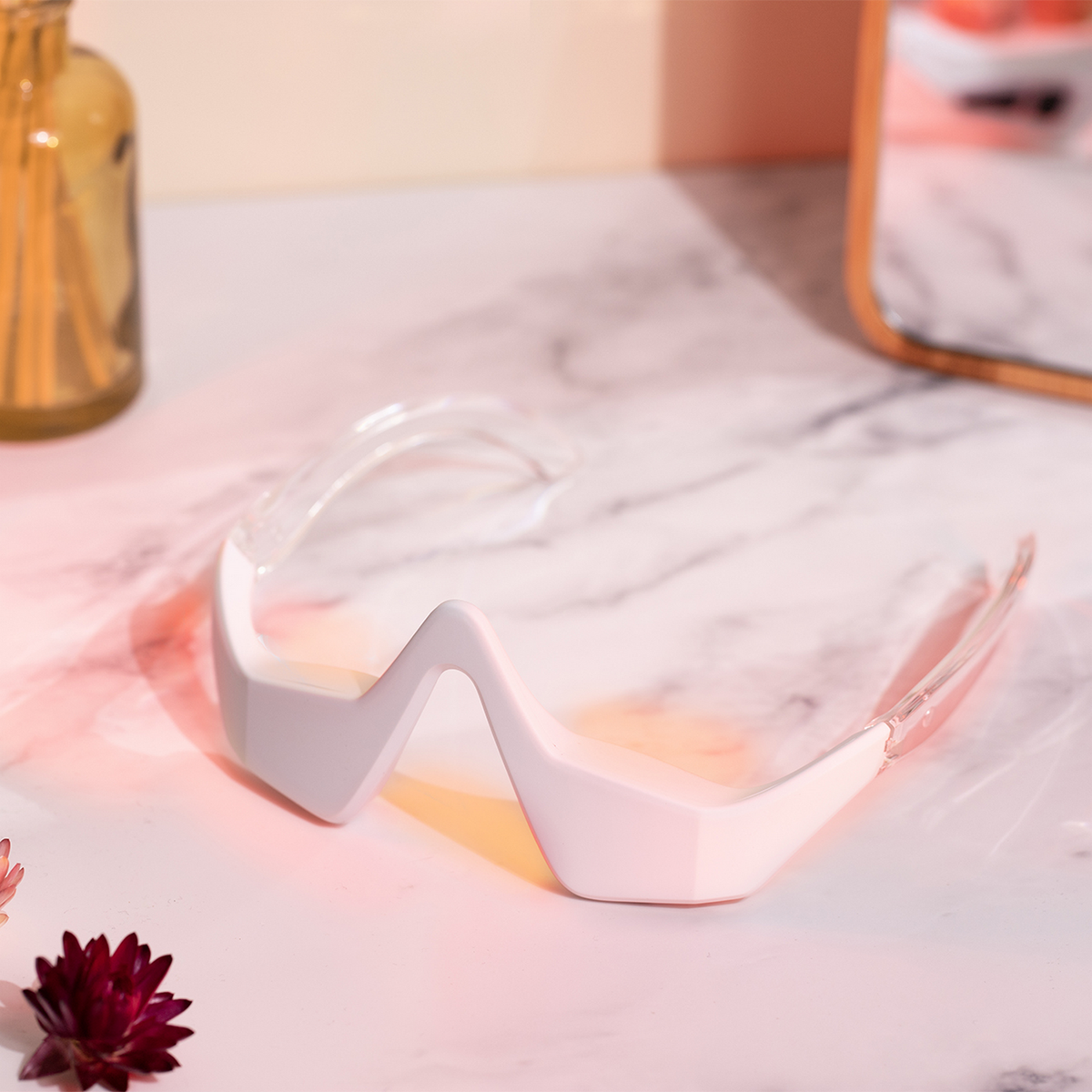 Un dispositivo di bellezza bianco a forma di zigzag con braccia trasparenti.
