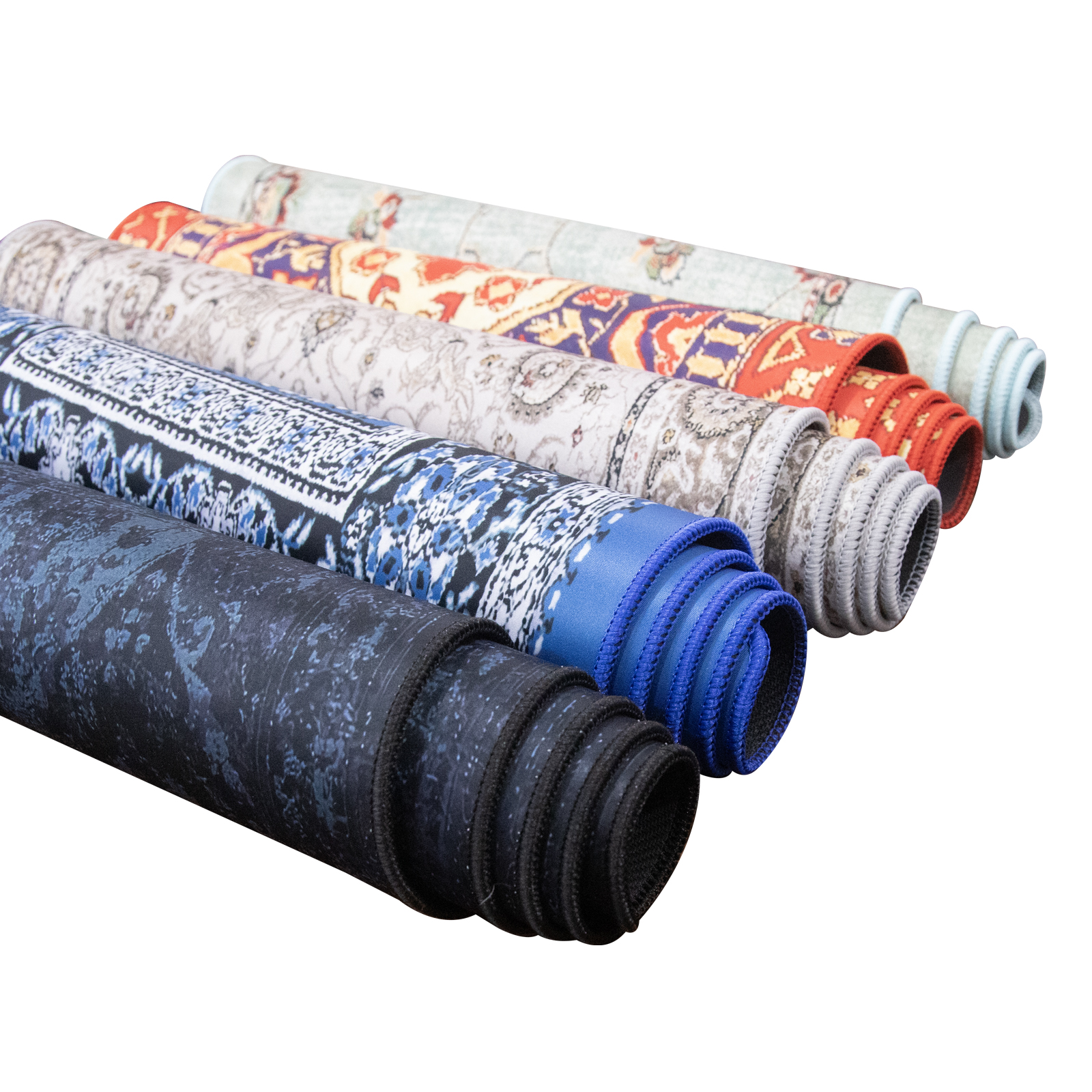 Kilka zwiniętych dywanów o różnych wzorach i kolorach.