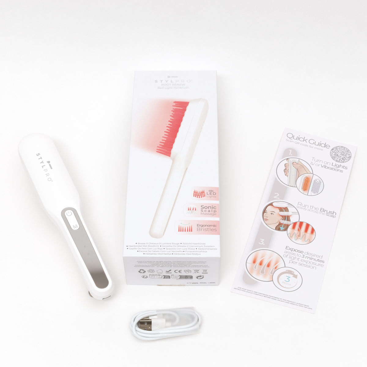 Un controller per spazzola per capelli bianco, una scatola e una guida giacciono su uno sfondo bianco.