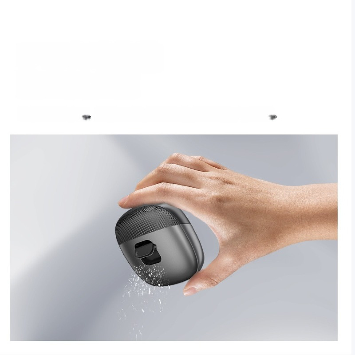 Dłoń trzyma ciemny, owalny czyścik, z którego spada kurz.