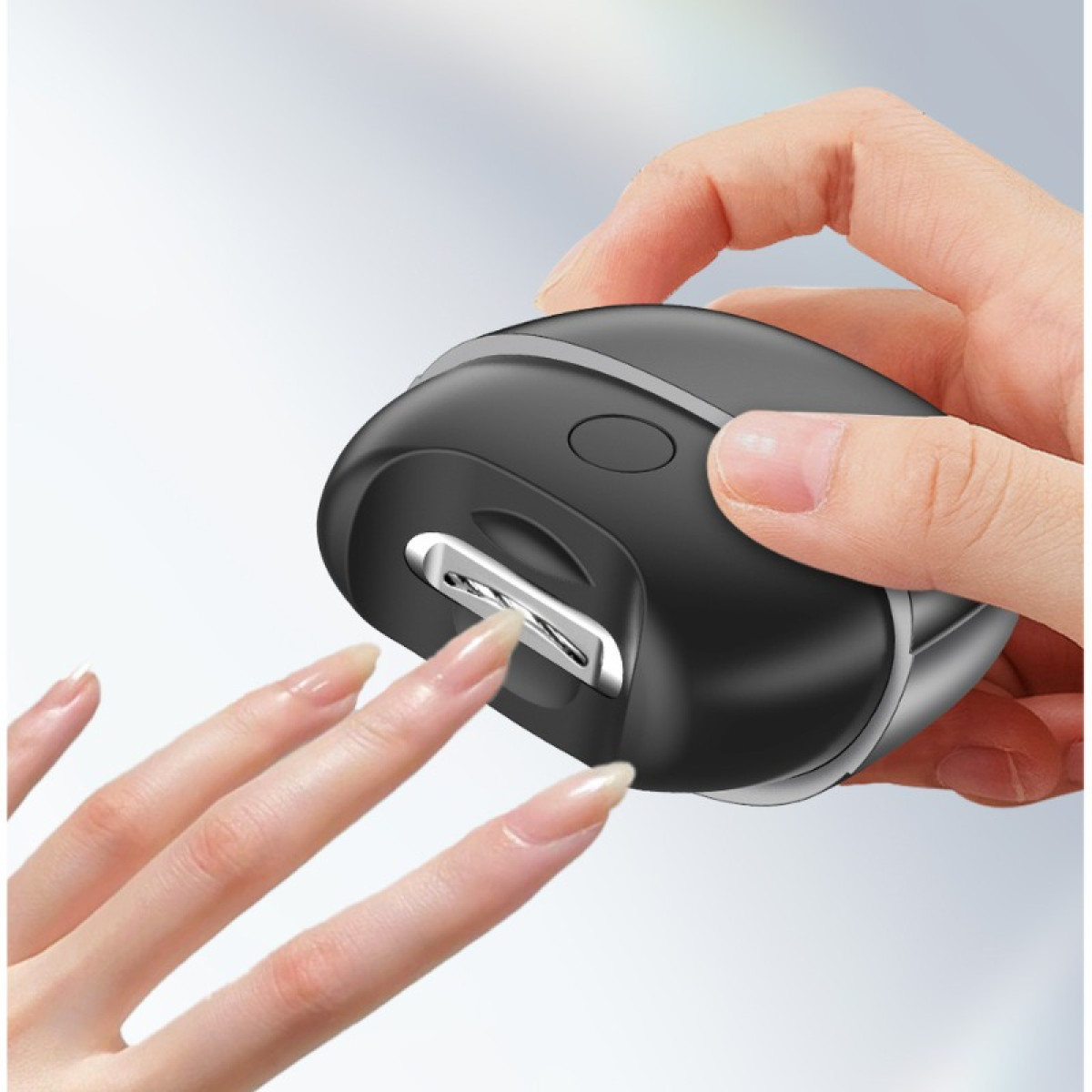 Dłoń trzyma czarny przycinacz do paznokci używany na paznokciu.