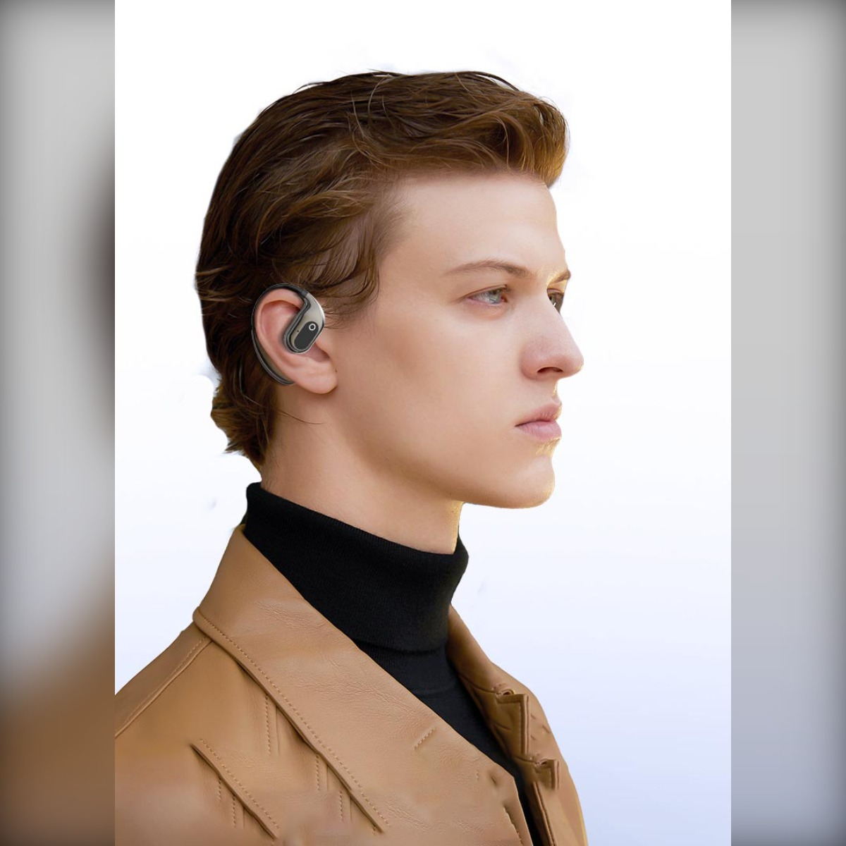 Mężczyzna z brązowymi włosami nosi czarny golf i brązową kurtkę skórzaną.